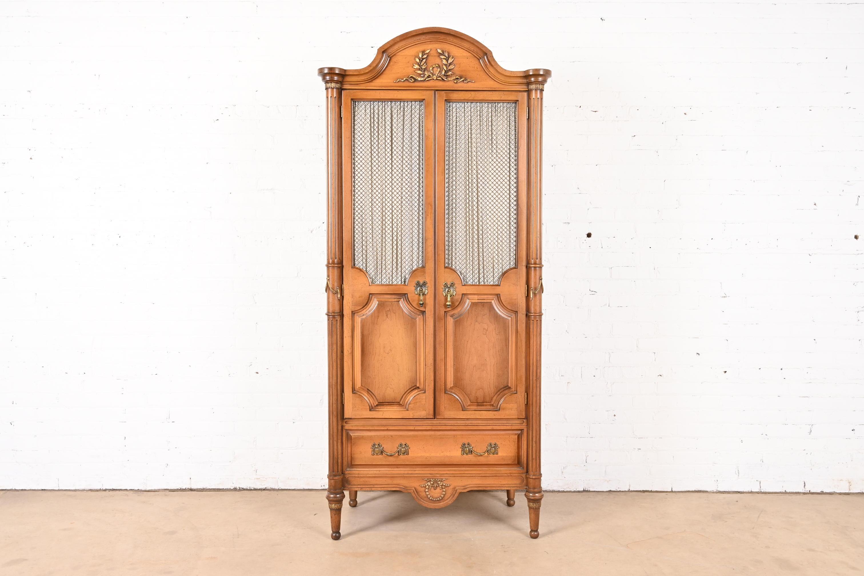 A gorgeous French Regency Louis XVI style armoire dresser or linen press

In the manner of Karges

USA, Circa 1960s

Carved fruitwood, with gold gilt details and original brass hardware.

Measures: 35.5