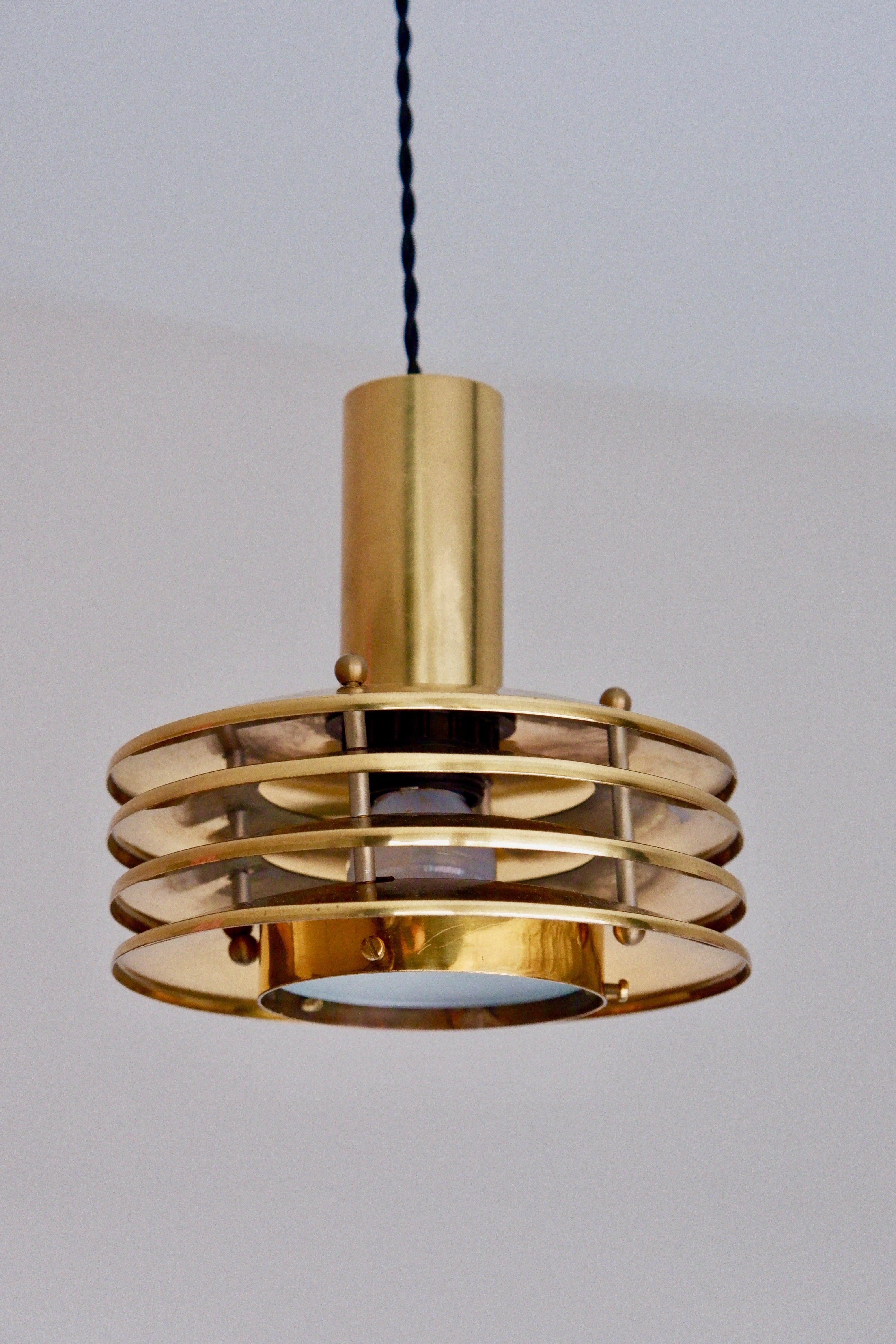 Ceiling light design by Kai Ruokonen. The design is typically Ruokonen style with the layers of brass shade. The lower part welcome a frosted glass on the bottom to hide the light.