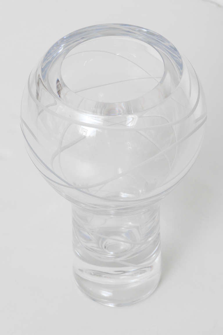 Ce magnifique vase en verre de cristal conçu par Karim Rashid pour Nambe présente de profondes incisions et des lignes texturées en forme de 8 dans ce lourd vase. Il a de la dimension et de la texture. La partie supérieure est coupée à plat.