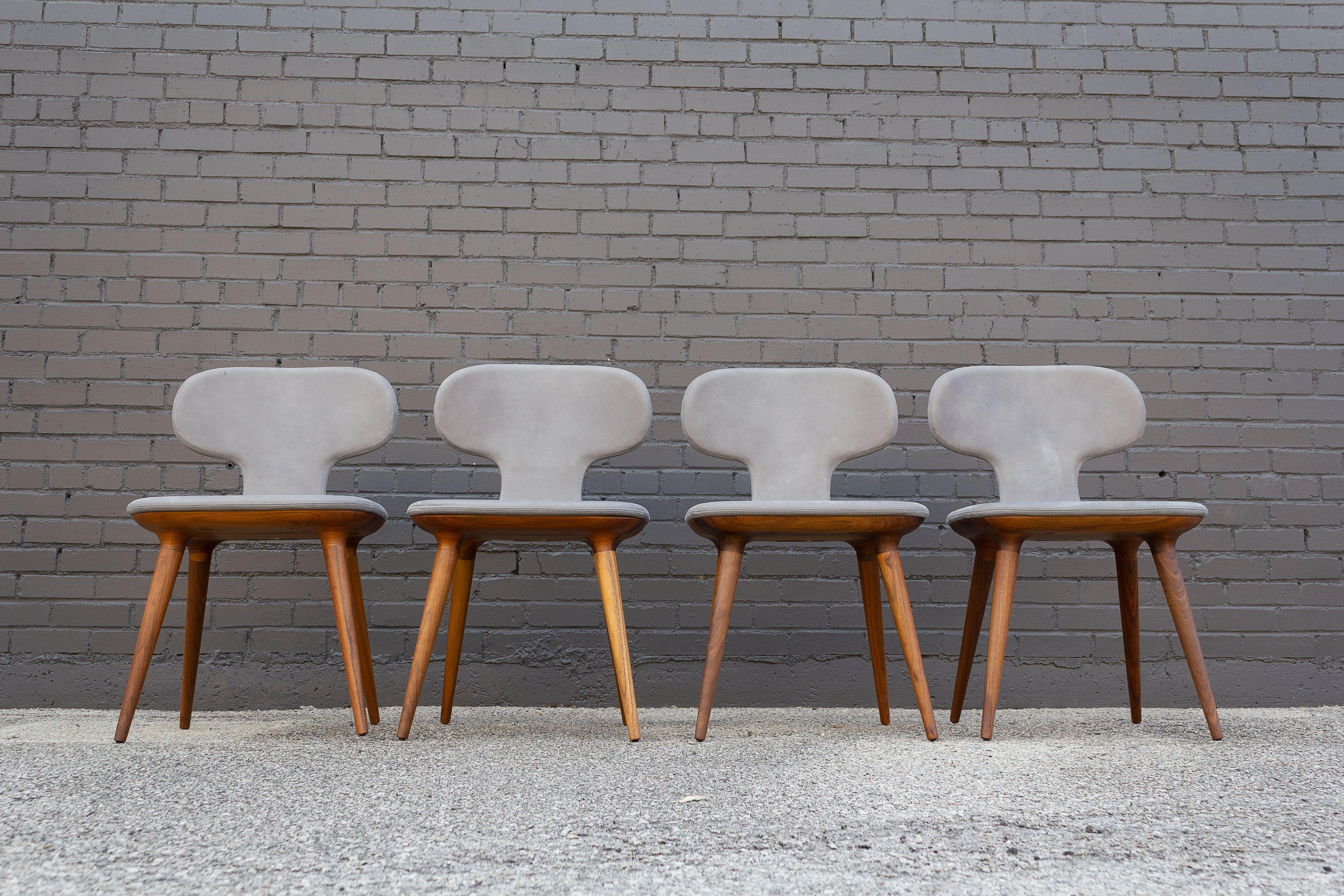 The Klutch chair was designed by Karim Rashid for Riva 1920 in collaboration with Lamborghini. The upholstered chairs are covered with hand-stitched suede leather and solid walnut sculpted bases. They were created to provide the same level of luxury