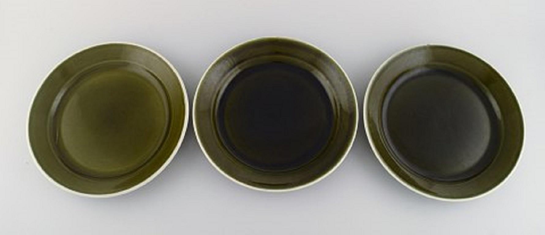 Karin Björquist (1927-2018) for Gustavsberg. Nine Vardag plates in glazed stoneware. 
Beautiful glaze in olive green tones,
Mid-20th century.
Measure: Diameter: 25 cm.
In excellent condition.
Stamped.