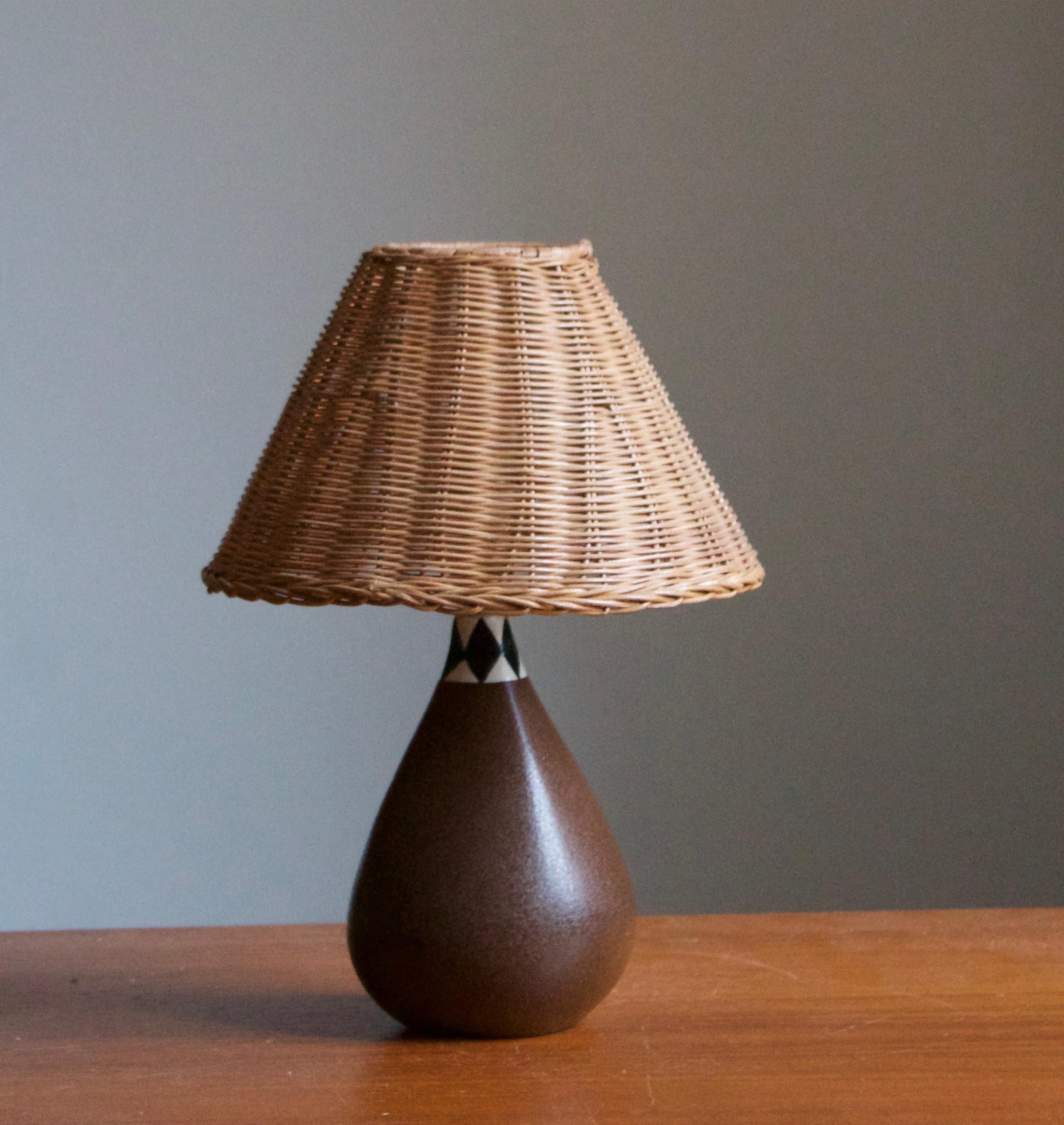 A table lamp mounted atop a small vase. Designed by Karin Björquist for Gustavsberg. Sweden, c. 1950s-1960s.

Stated dimensions exclude lampshade. Height includes socket. Upon request illustrated vintage rattan lampshade can be included in