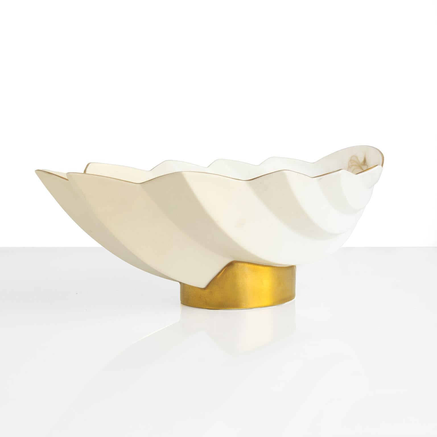 Elegante cuenco escandinavo moderno con pie de cerámica esmaltada blanca y detalles dorados. Diseñado por Karin Bjórquist para Rörstrand, Suecia, firmado y fechado en la década de 1990 en la parte inferior.

Altura: 8 Anchura: 7 Profundidad: 12,5
