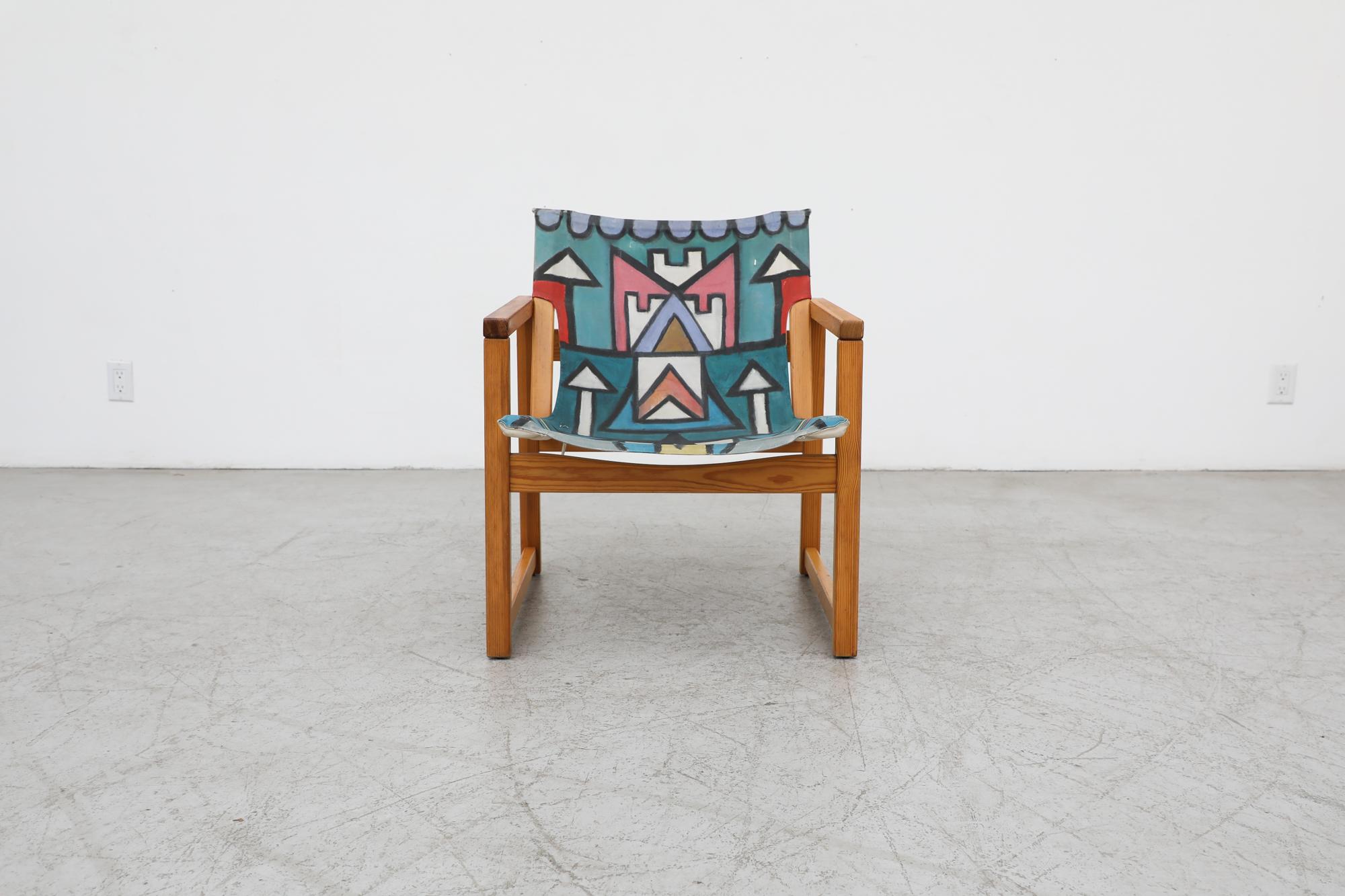 This pine Safari chair with canvas seating and leather strapping that was designed by Swedish Mid Century Design pioneer Karin Mobring has been hand painted by an unknown artist. Fun vibrant Memphis inspired design in original condition with visible