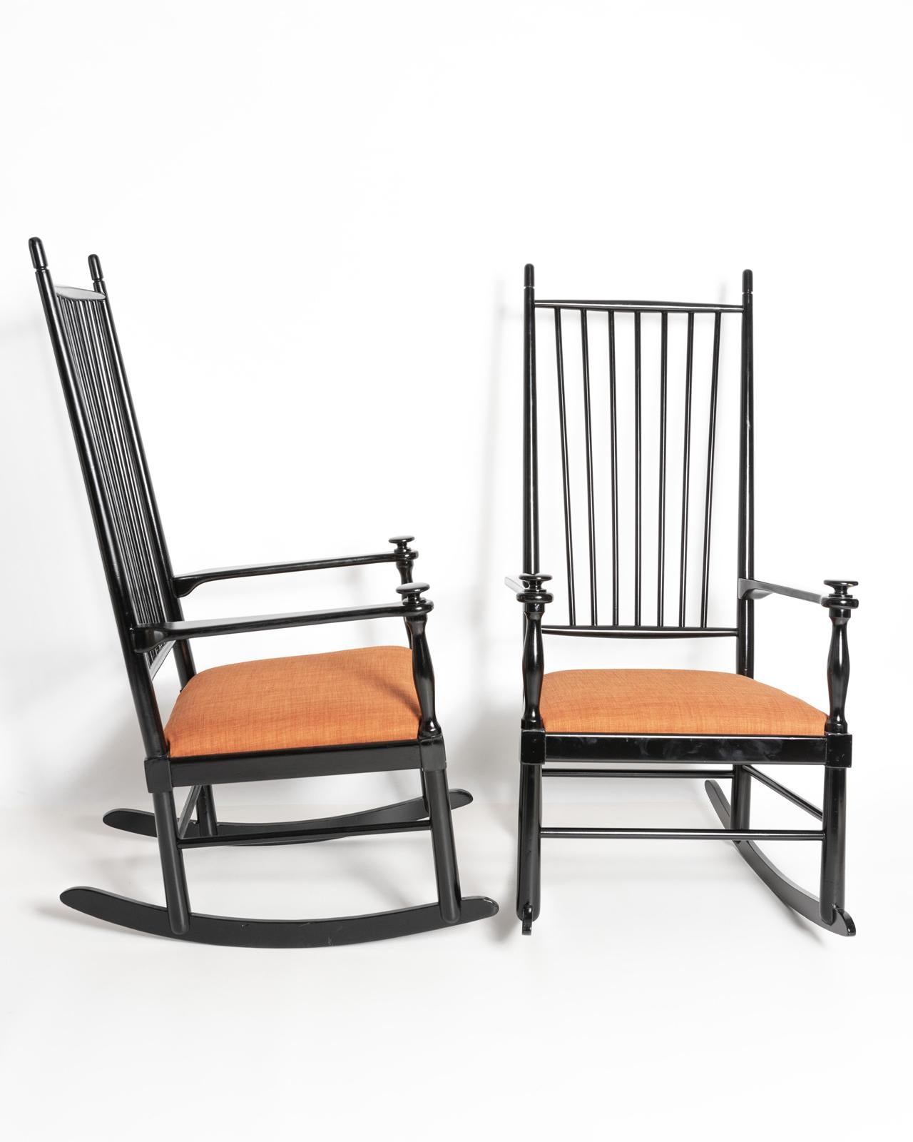 A pair of  Swedish 'Isabella' D10 Karl Axel Adolfsson, rocking chairs in ebonised beech wood with upholstered seats in burnt orange. 