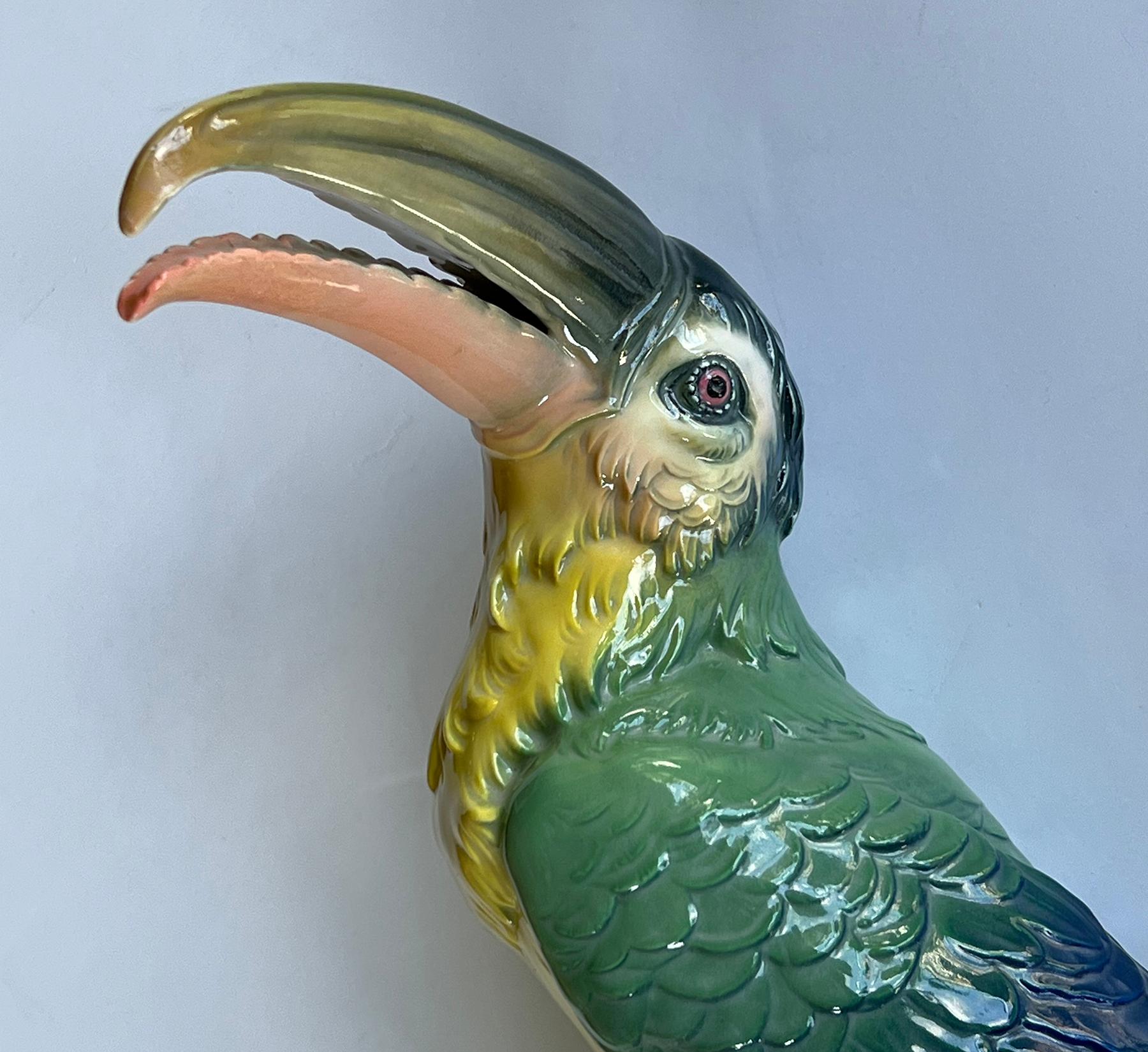 le toucan aux détails complexes, avec son bec courbé spectaculaire au-dessus d'un corps finement plumé reposant sur une branche feuillue ; le tout dans une finition colorée peinte et émaillée à la main ; marqué sur le dessous d'un moulin à vent vert