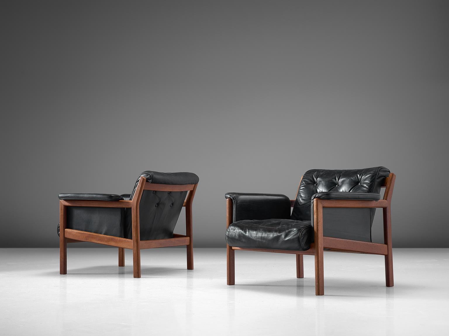 Karl-Erik Ekselius for JOC, pair of lounge chairs, leather and teak, Sweden, 1960s.

This set of 2 arm chairs feature a teak frame with slatted back and an angular, geometric frame. It contains a tufted seat and back are comfortable and support