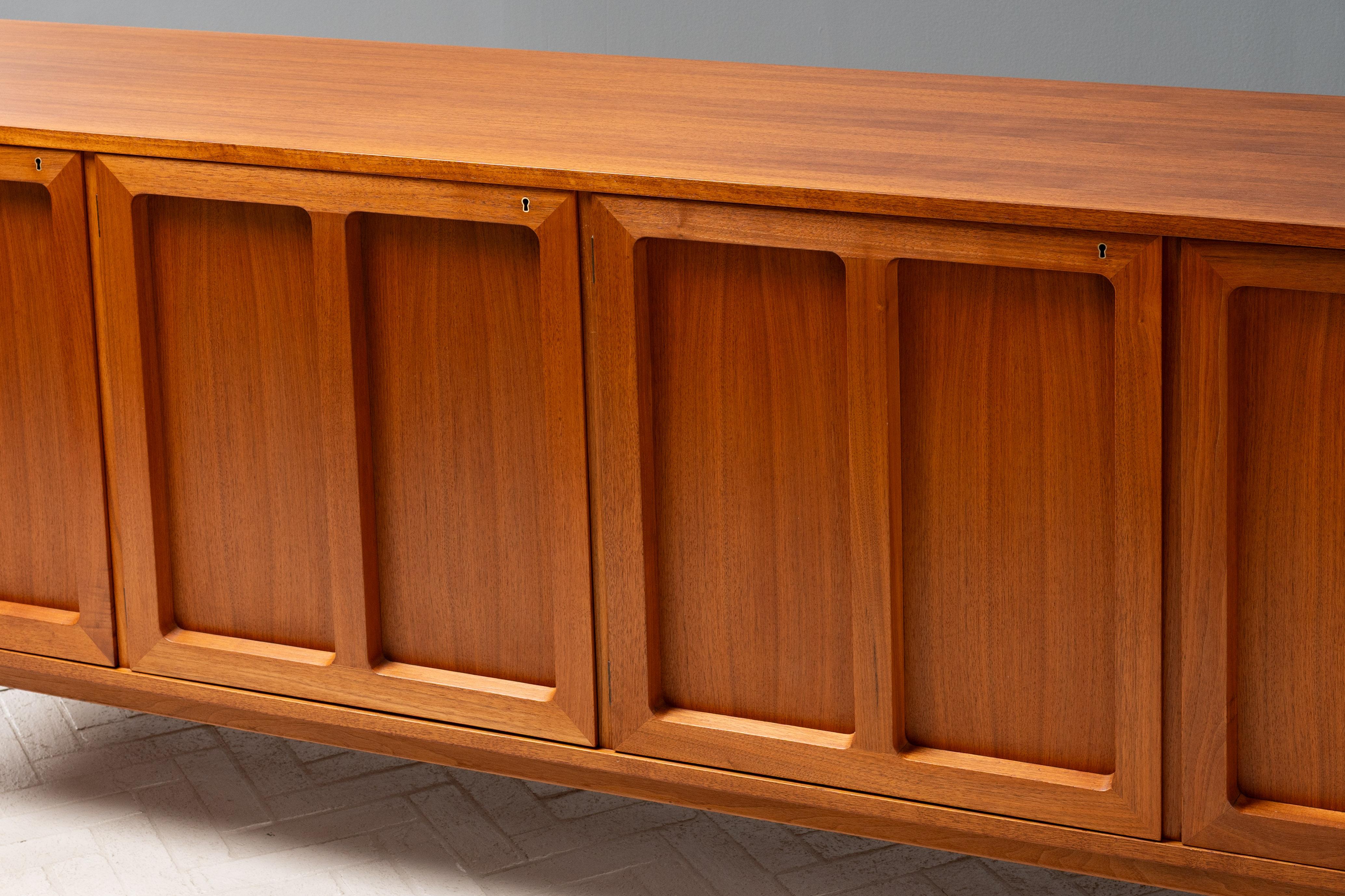 Sweden, ca. 1960s. A scarce sideboard Karl Erik Ekselius for J. O. Carlsson. Features high quality teak construction with four elegantly designed paneled doors supported by minimalist square feet. Far left cabinet opens to reveal six shallow drawers