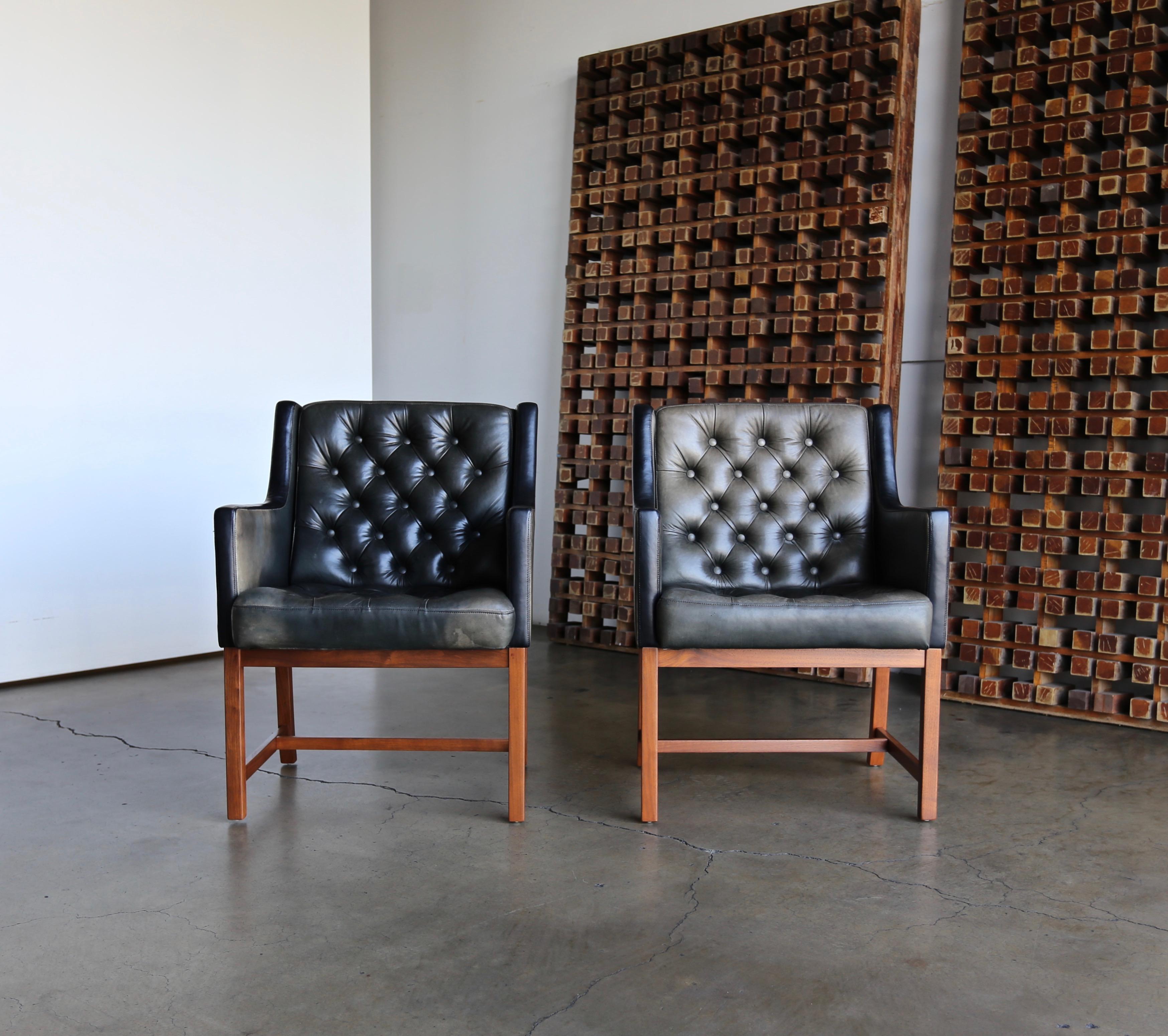 Karl Erik Ekselius tufted leather chairs for JOC, Sweden, circa 1960. This pair retains its original patina to the original leather. The solid teak bases have been professionally restored.