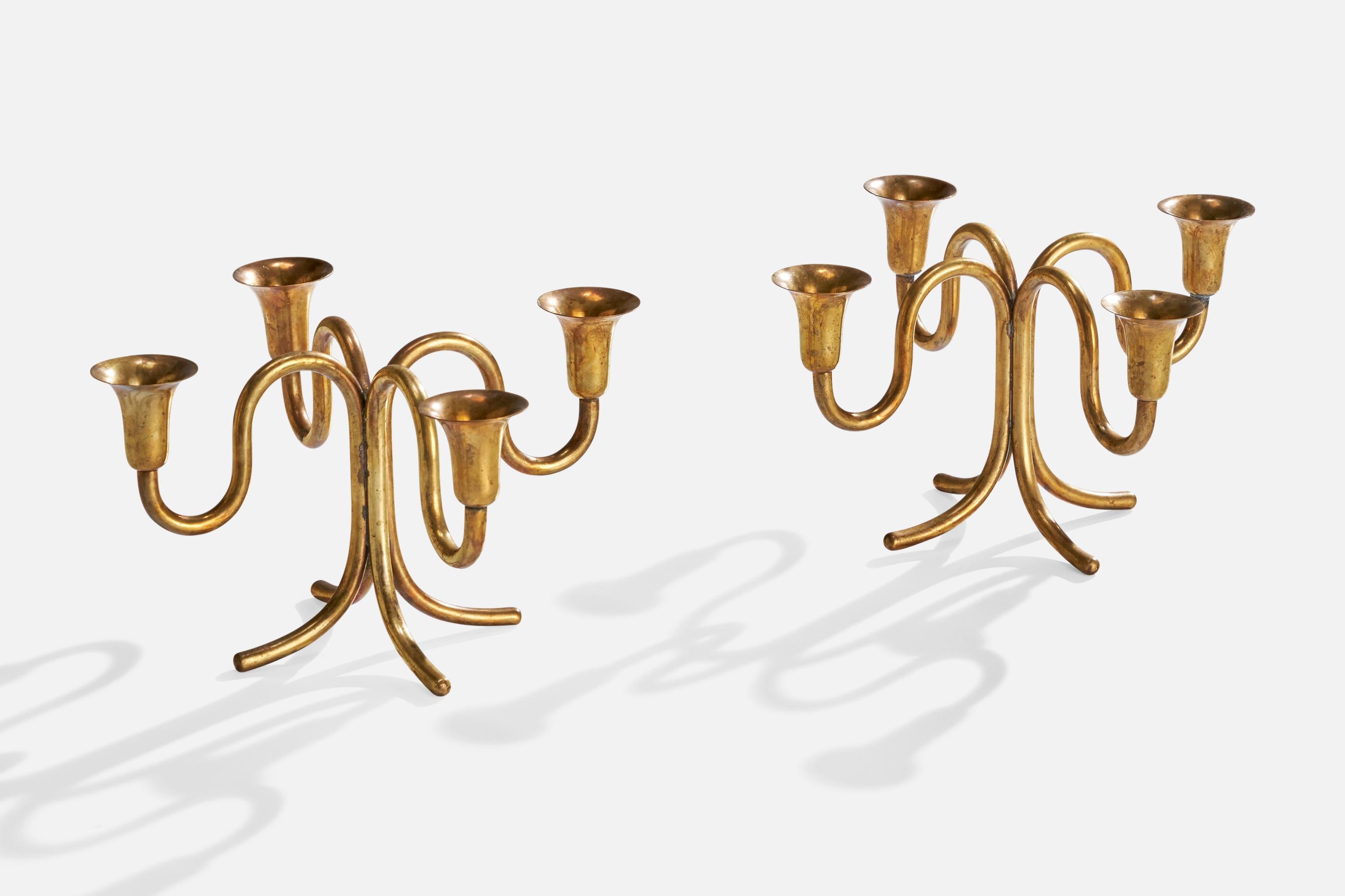 A pair of brass candelabras designed by Karl Hagenauer and produced by Werkstätte Hagenauer, Vienna, Austria, c. 1940s.

dimensions: 6.375” H x 11.5” diameter 

Holds 1” diameter candles 