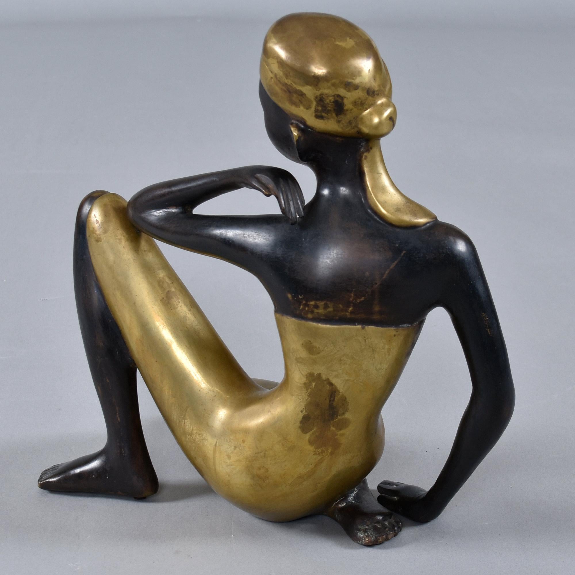 Remarquable sculpture en bronze du milieu du XXe siècle, réalisée dans le style admiré de la Werkstätte Hagenauer, cette femme africaine assise reflète l'esprit moderniste et l'élégance exotique qui ont rendu l'atelier viennois de Hagenauer célèbre