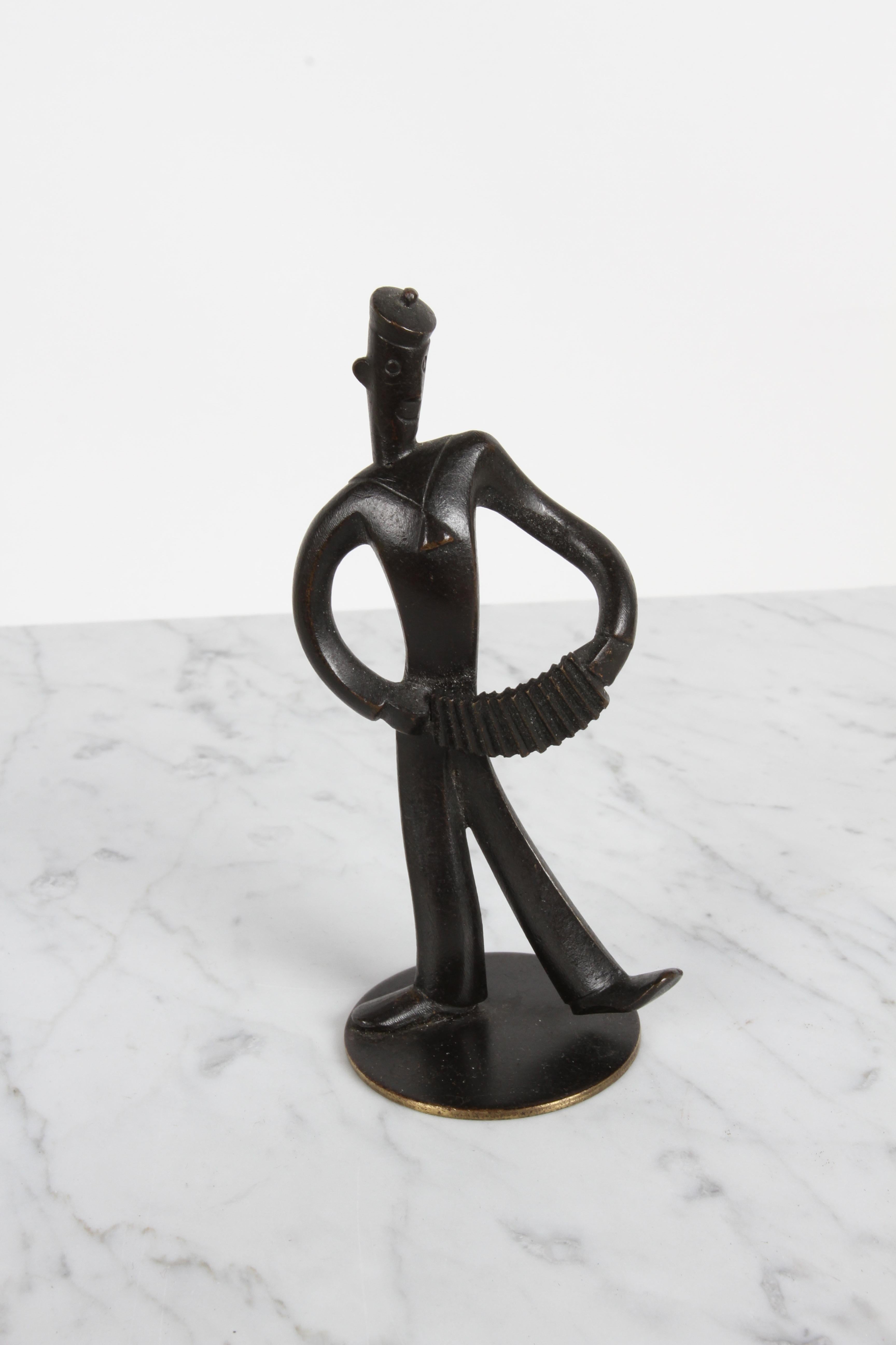 Karl Hagenauer per Werkstätte Hagenauer Wienstamp - timbro WHW, Hagenauer Wein made in Austria, miniatura in bronzo degli anni '30 circa di un marinaio che suona una fisarmonica. 


