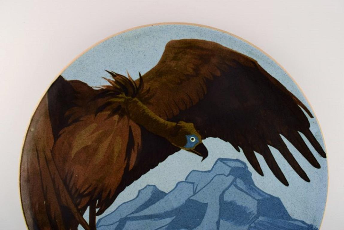 Karl Hansen Reistrup (1863-1929) for Kähler. Colossal unique dish in glazed ceramics. 
Vulture and mountain landscape. 
Museum quality. Approx. 1900.
Measures: 42 x 5 cm.
In excellent condition.
Signed: HAK.