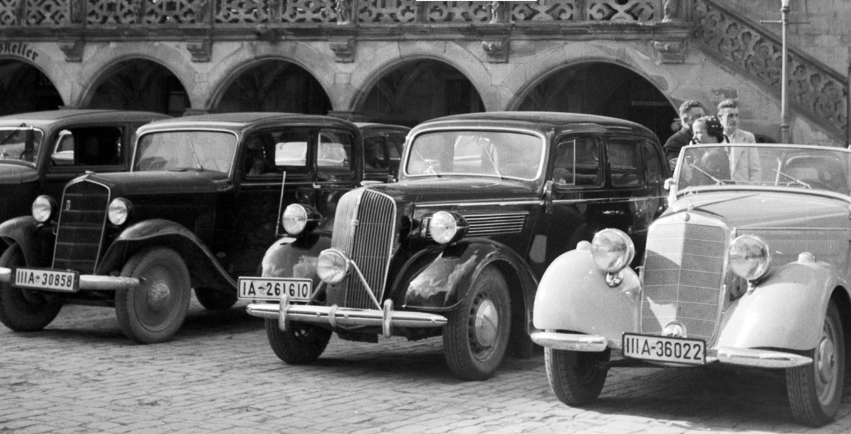 Cars parking at old Heidelberg city hall, Germany 1936, Printed Later  - Photograph by Karl Heinrich Lämmel