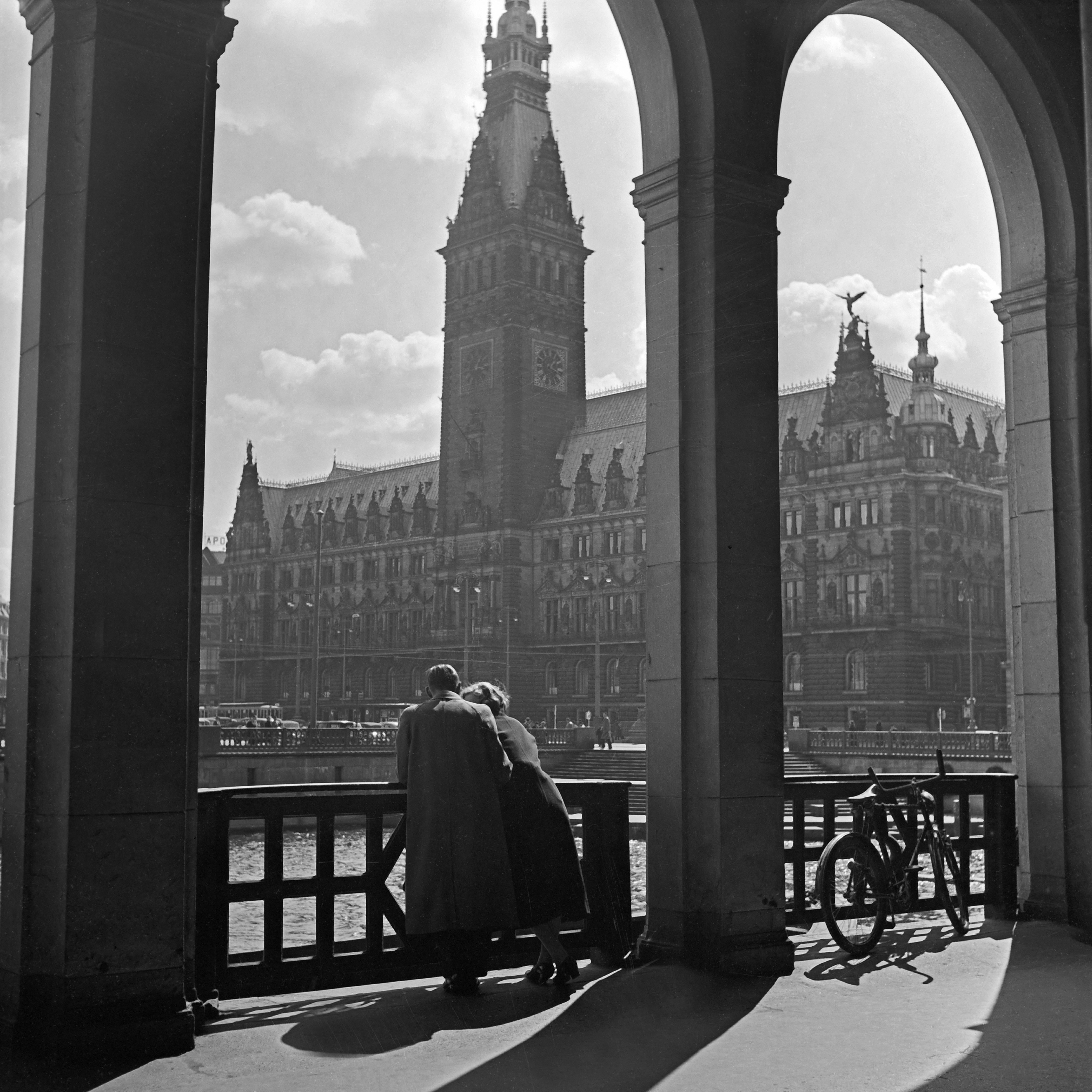Black and White Photograph Karl Heinrich Lämmel - Couple debout à la colonnade jusqu'à l'hôtel de ville de Hambourg, Allemagne 1938, Imprimé plus tard 