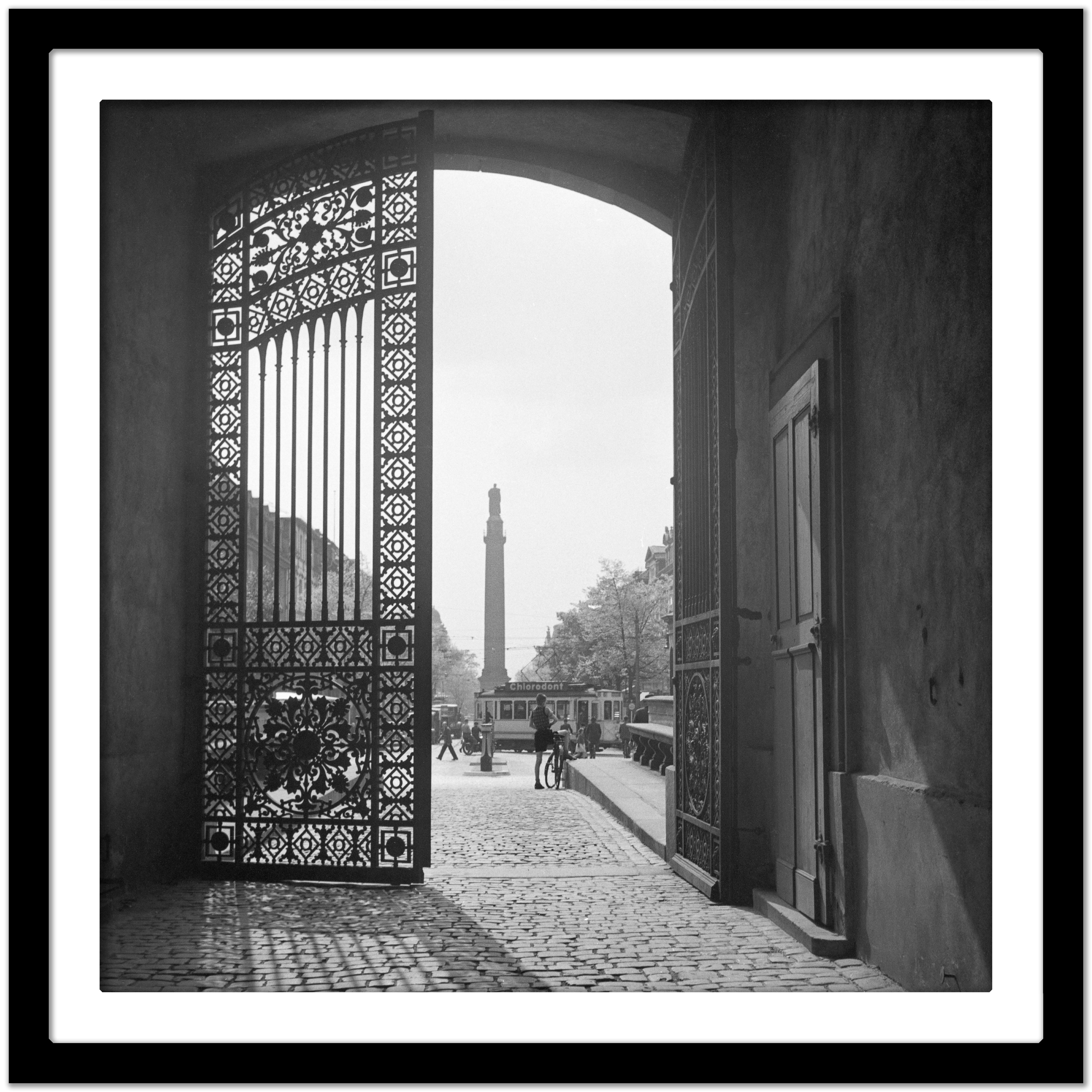 View from iron gate to city life Darmstadt, Germany 1938 Printed Later  - Black Black and White Photograph by Karl Heinrich Lämmel