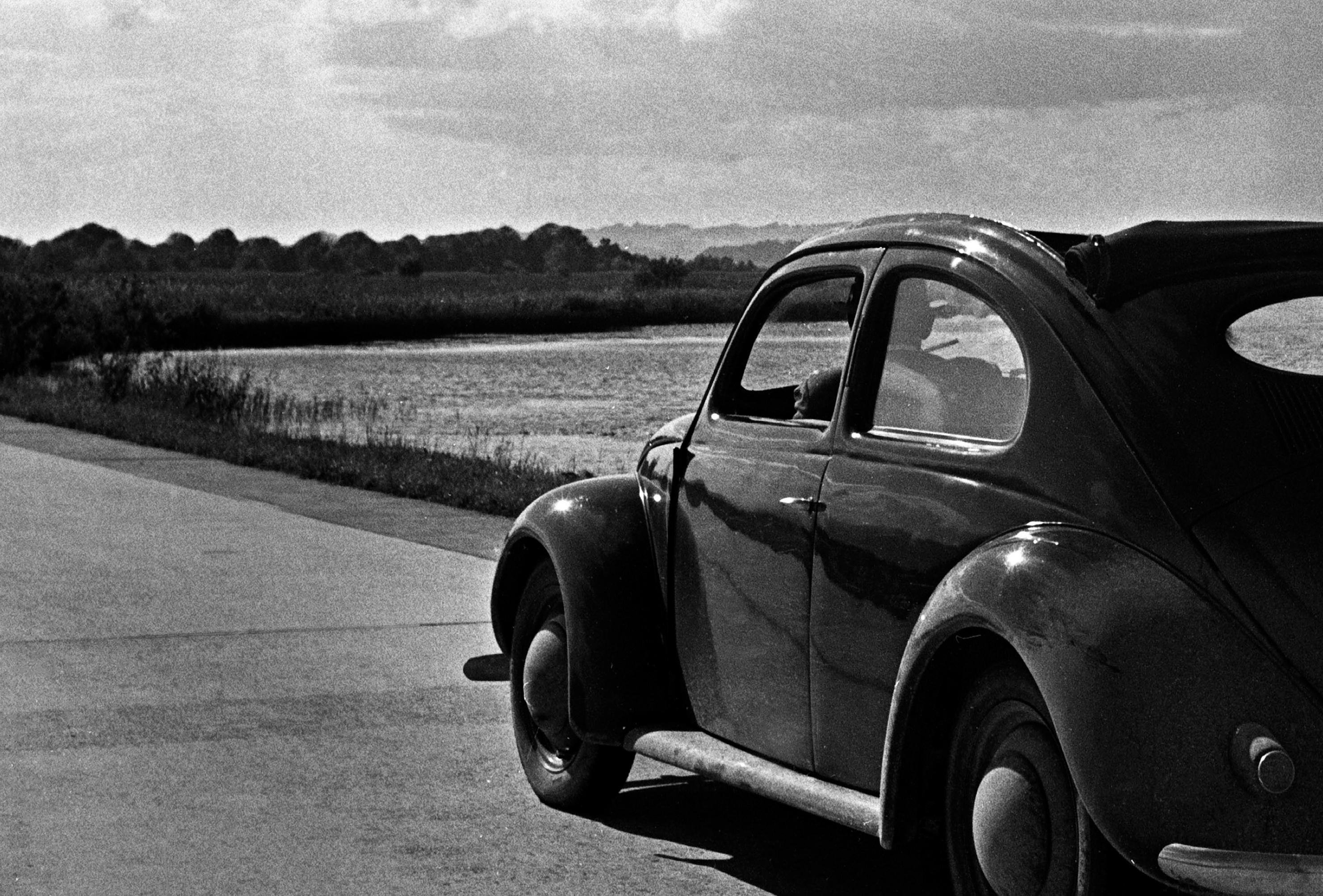 Volkswagen Käfer auf den Straßen neben dem Meer, Deutschland 1939 Später gedruckt  – Photograph von Karl Heinrich Lämmel