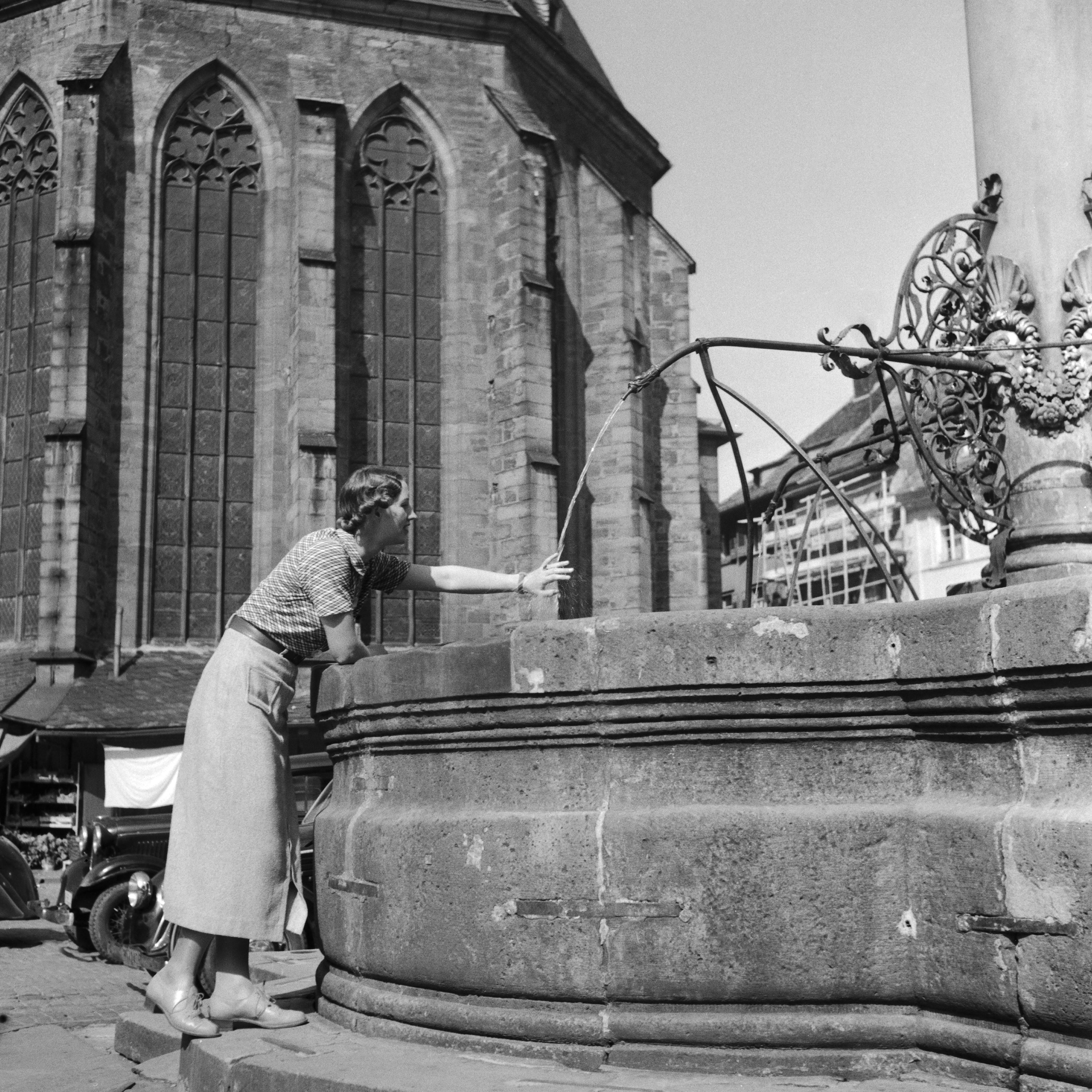 Karl Heinrich Lämmel Black and White Photograph - Woman, fountain, Heiliggeist church Heidelberg, Germany 1936, Printed Later 