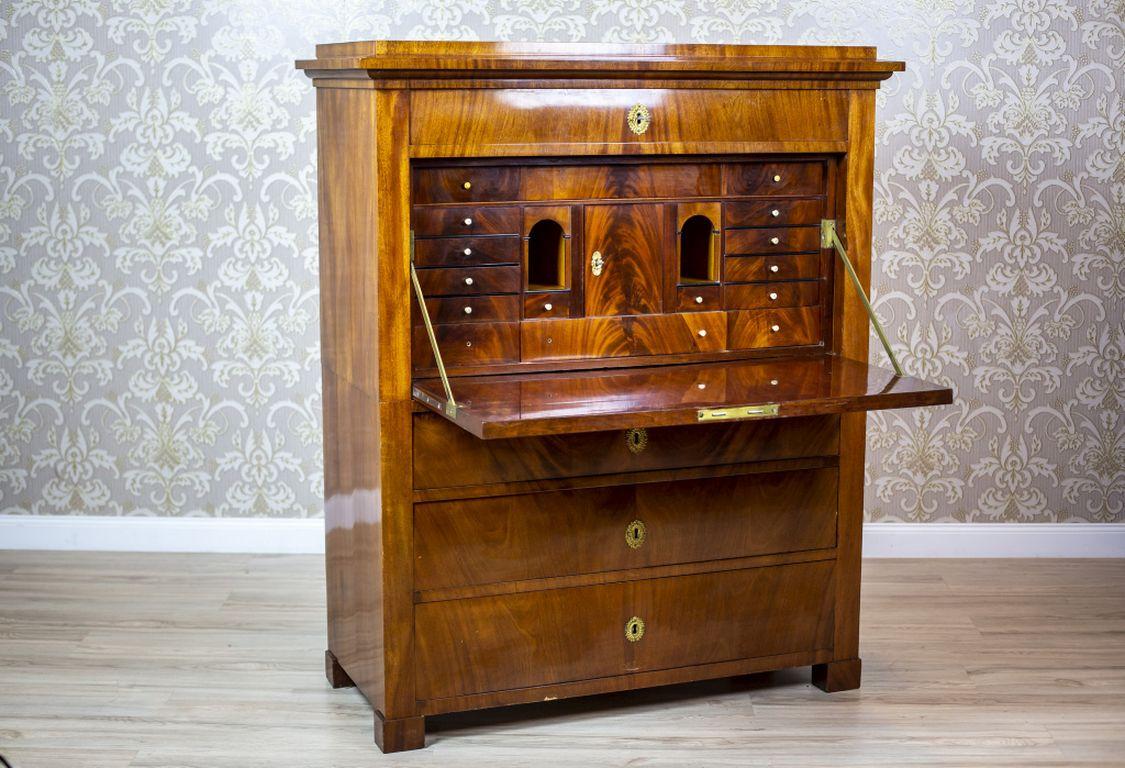 We present you a signed Karl Johan secretary from 1833. 
This case piece of furniture is of a simple form, with three drawers at the bottom, a removable top, and a drawer under the cornice. 
Furthermore, the top is flush with the front, and hides