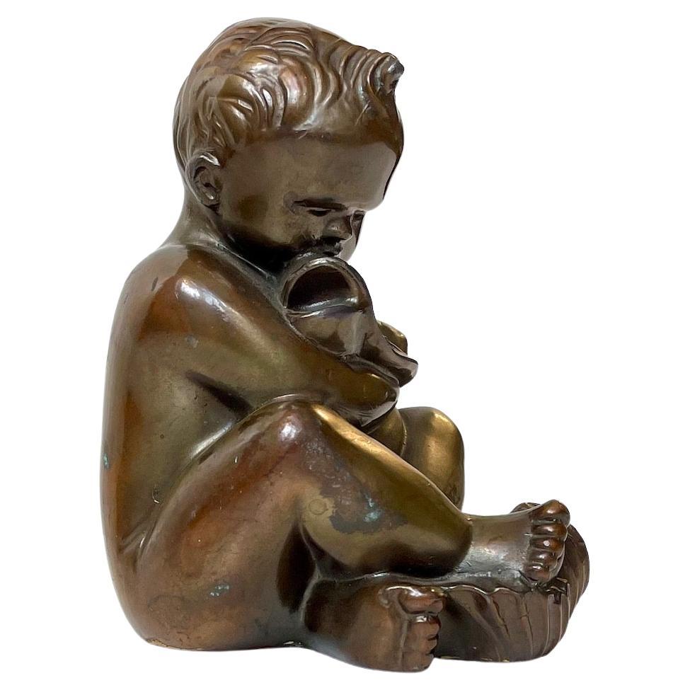 Stylized and mythological small bronze sculpture depicting a baby boy embracing a fish. Designed and studio cast by German Sculptor Karl Josef Hoffmann (1925-59) during the 1940s or 50s. Signed KJH to the side. Measurements: H: 14, D: 10, W: 7 cm.