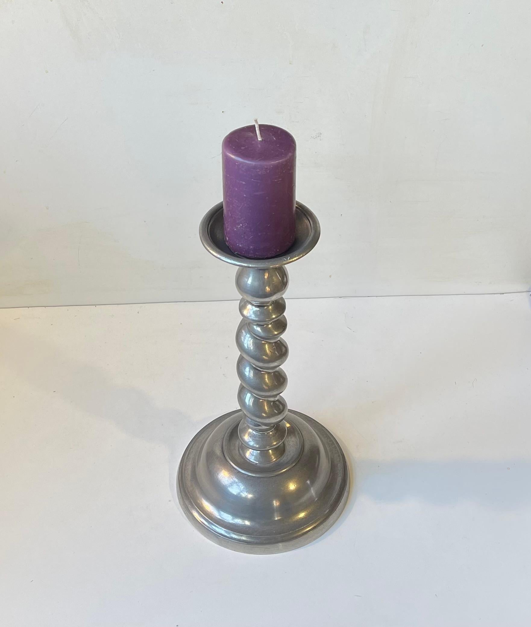 Raro candelabro de iglesia para velas de bloque o de bola. Está diseñado y fabricado por el orfebre noruego Karl Jørgen Otteren. Ejecutado en peltre retorcido. Sello/inscripción Otteren. 

Medidas: H: 32 cm, Diámetro: 10/18 cm (parte superior/base).