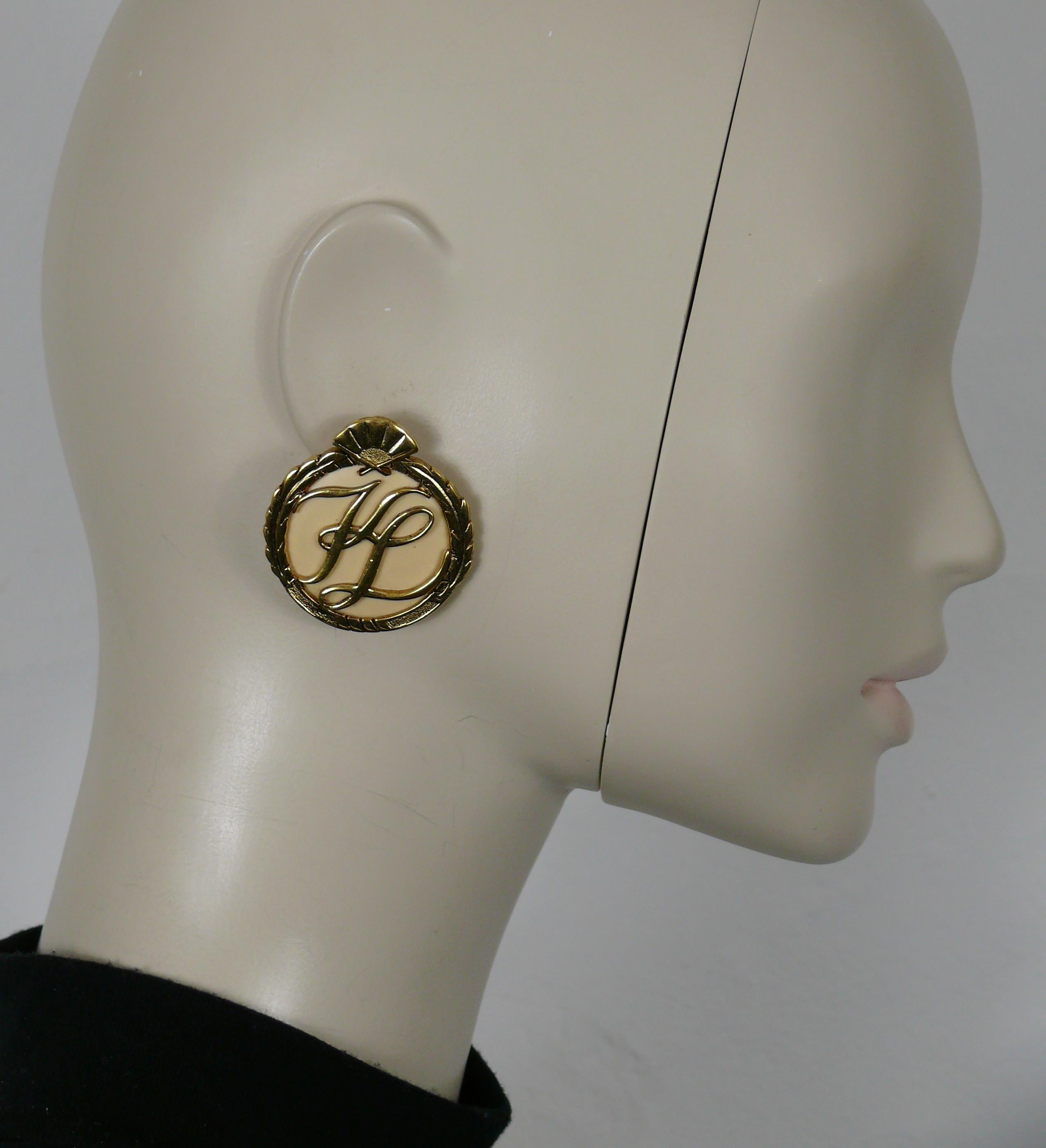 KARL LAGERFELD Vintage-Ohrringe mit ikonischen goldfarbenen Ohrringen mit KL-Initialen in der Mitte, weißem Harzhintergrund und Fächer an der Spitze.

Geprägte KL auf den Rückseiten.

Ungefähre Maße: Durchmesser 4 cm (1,57 Zoll).

Gewicht pro