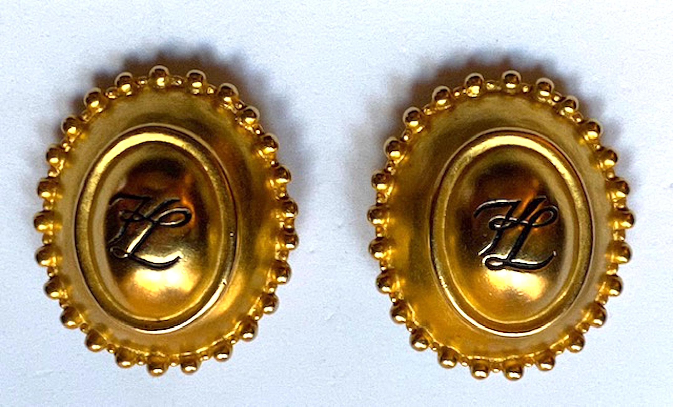 Karl Lagerfeld 1980s satin gold plate oval button earrings with KL monogram. Each earring is a domed button measuring 1.38 inches wide, 1.63 inches long an .63 of an inch high. The back has the Lagerfeld fan along with a circle stamp with KL script