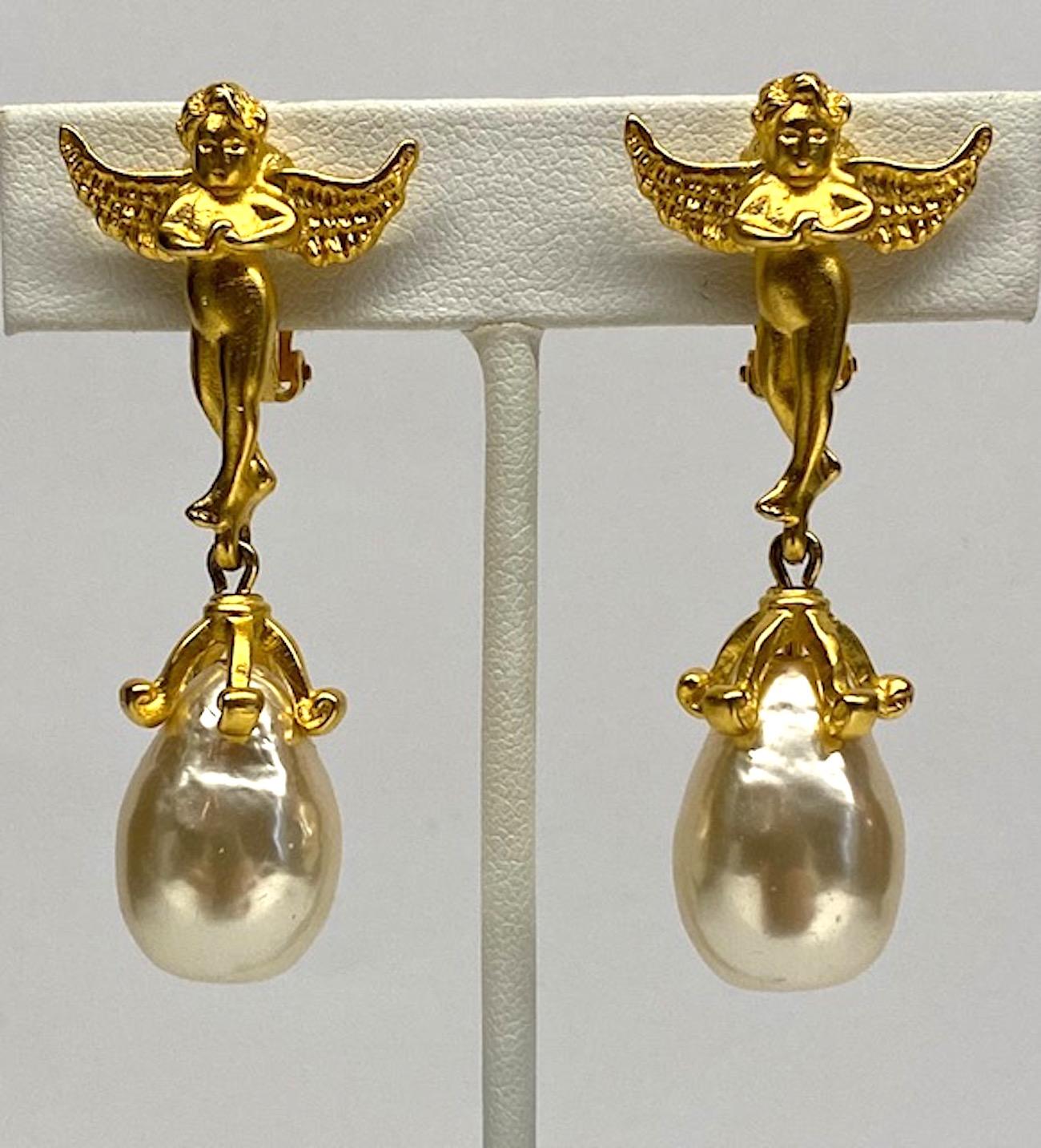 A beautifully cast pair of Karl Lagerfeld 1980s winged cherub earrings in satin gold with pear shape pearl pendants. The cherubs are three dimensional with clip back. The pear shape faux Baroque pearls are mounted into a five prong top setting. Each