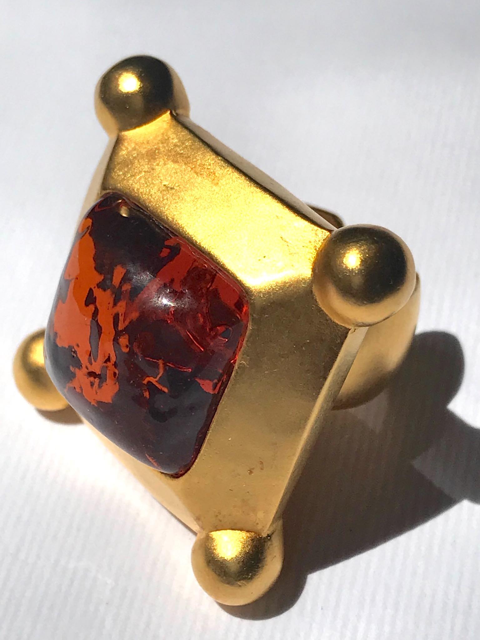 A rare 1980s satin gold finish ring with poured glass stone by Karl Lagerfeld. The square amber glass stone has a polished mottled texture. It is perfectly mounted into the setting from the back and fixed in place with prongs. The ring is cast in a