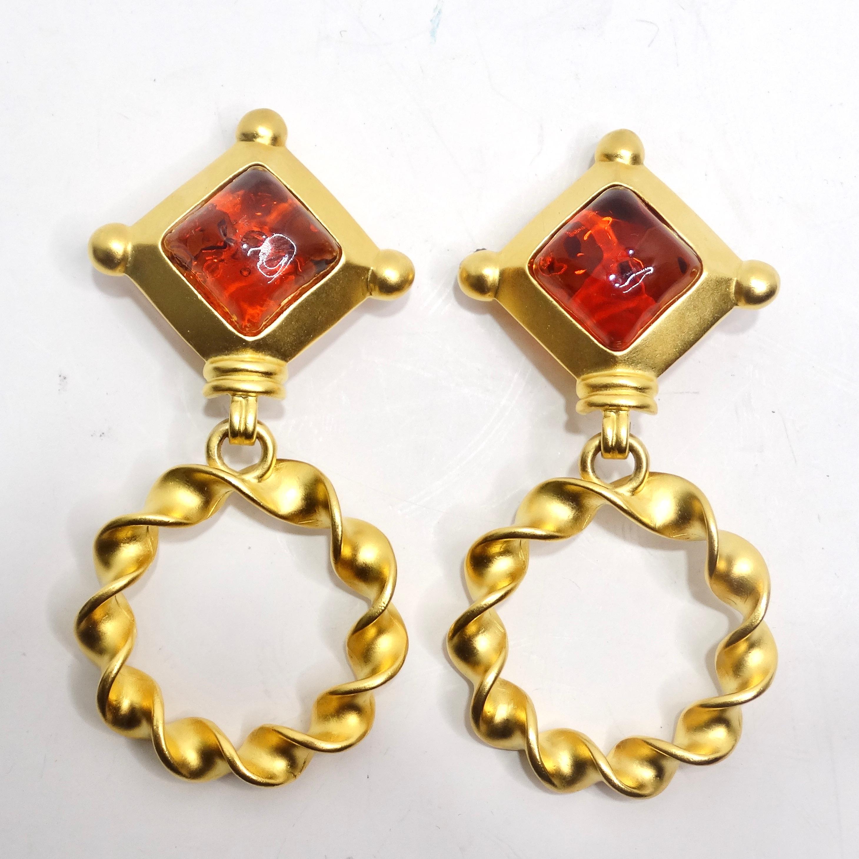 Step into the world of bold elegance with the Karl Lagerfeld 1980s Gold Plated Red Stone Dangle Earrings. These stunning yellow gold plated earrings are a true vintage masterpiece, featuring a captivating blood orange diamond-shaped stone encased in