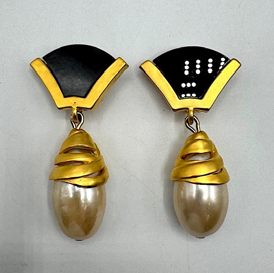 Un sorprendente paio di orecchini vintage anni '80 di Karl Lagerfeld, disegnati con l'estetica audace e scultorea tipica di Lagerfeld. Gli orecchini a clip sono caratterizzati da una parte superiore a forma di ventaglio in resina nera, incorniciata