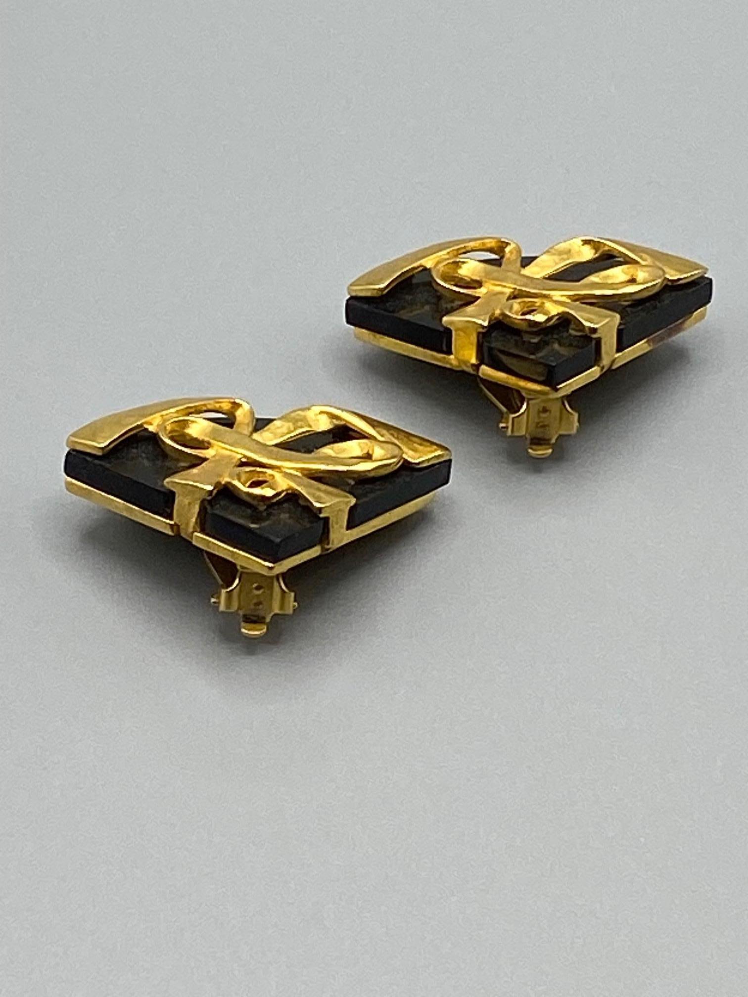 A beautiful pair of Karl Lagerfeld fan shape earrings from the mid to ate 1980s. The Lagerfeld fan is synonymous with his script KL initials as the company logo. Each earring is a rich satin gold tone and black resin. The ribbon style KL initials