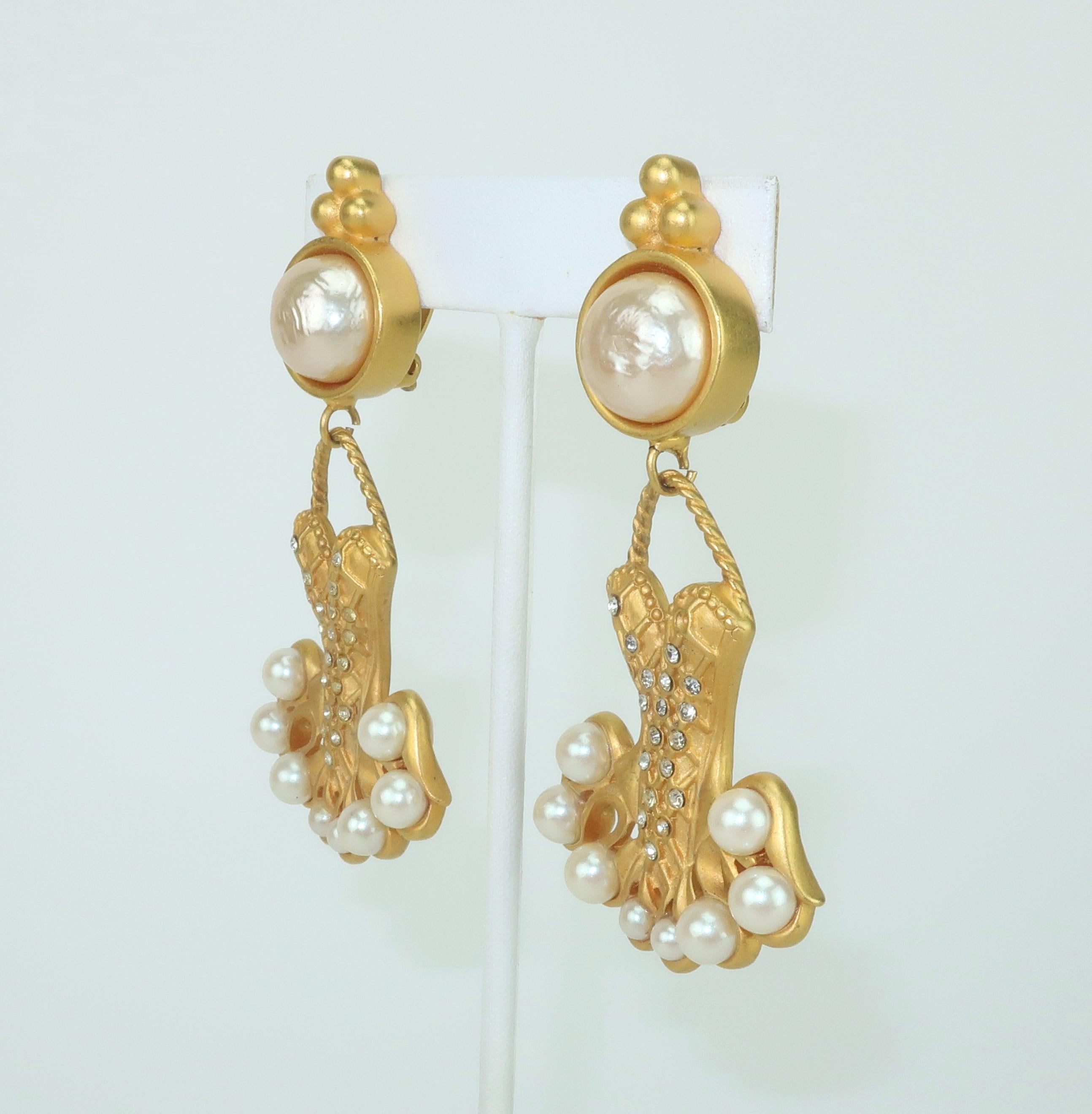 Favolosi orecchini Karl Lagerfeld placcati in oro a forma di tutù da ballerina impreziositi da finte perle e strass di cristallo.  Estrosità e glam nello stesso design!  Dotata di una chiusura a clip e di un marchio sul retro.  Indossale con il tuo