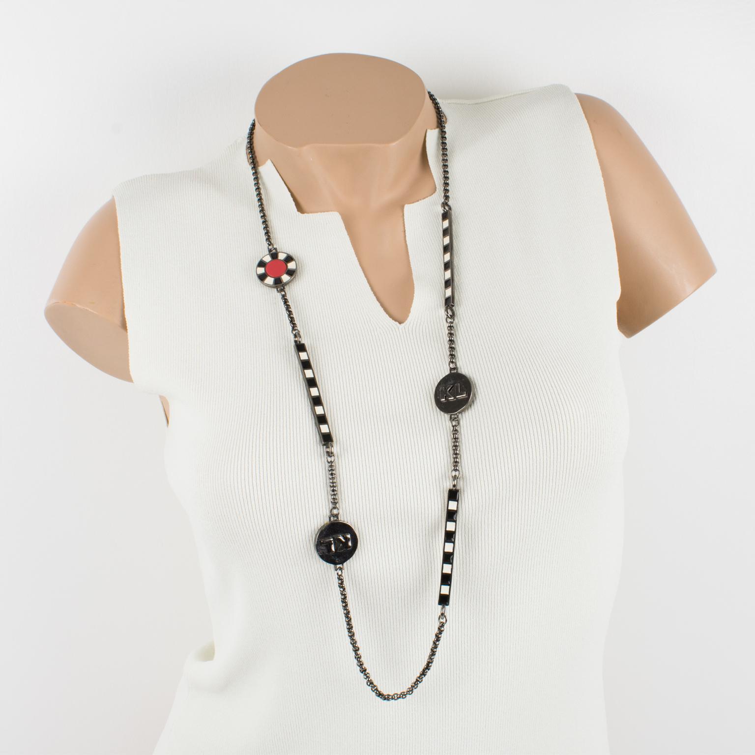 This elegant Karl Lagerfeld Paris extra-long sautoir necklace features a heavy gunmetal chain complimented with enamel bars and disks. The bars are ornate with black and white enameling on both sides, as the disks have black, white, and red