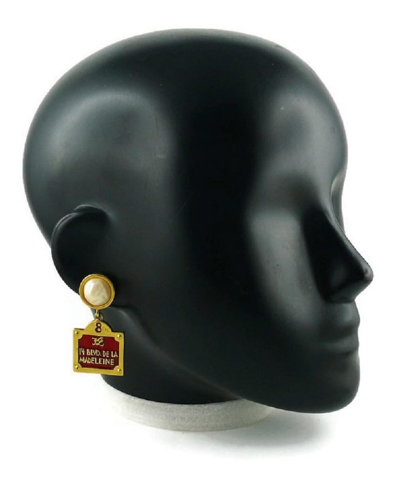 KARL LAGERFELD iconic vintage gold toned dangling earrings (for pierced ears) featuring a 14 Blvd De La Madeleine enameled street sign and a faux pearl top.

KL logo on the street sign.

Indicative measurements : height approx. 5 cm (1.97 inches) /