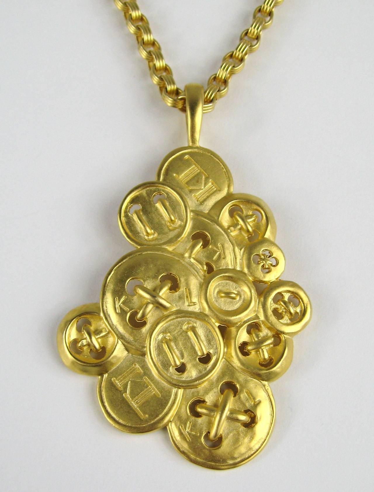 New Old Stock- (Never Worn)  Karl Lagerfeld Necklace Circa 1980s. Large Pendant of KL Buttons. Measuring 3.64 inches x 2.28 inches. Chain is 38 inches end to end with Adjustable length. This is out of a massive collection of New Old stock items as