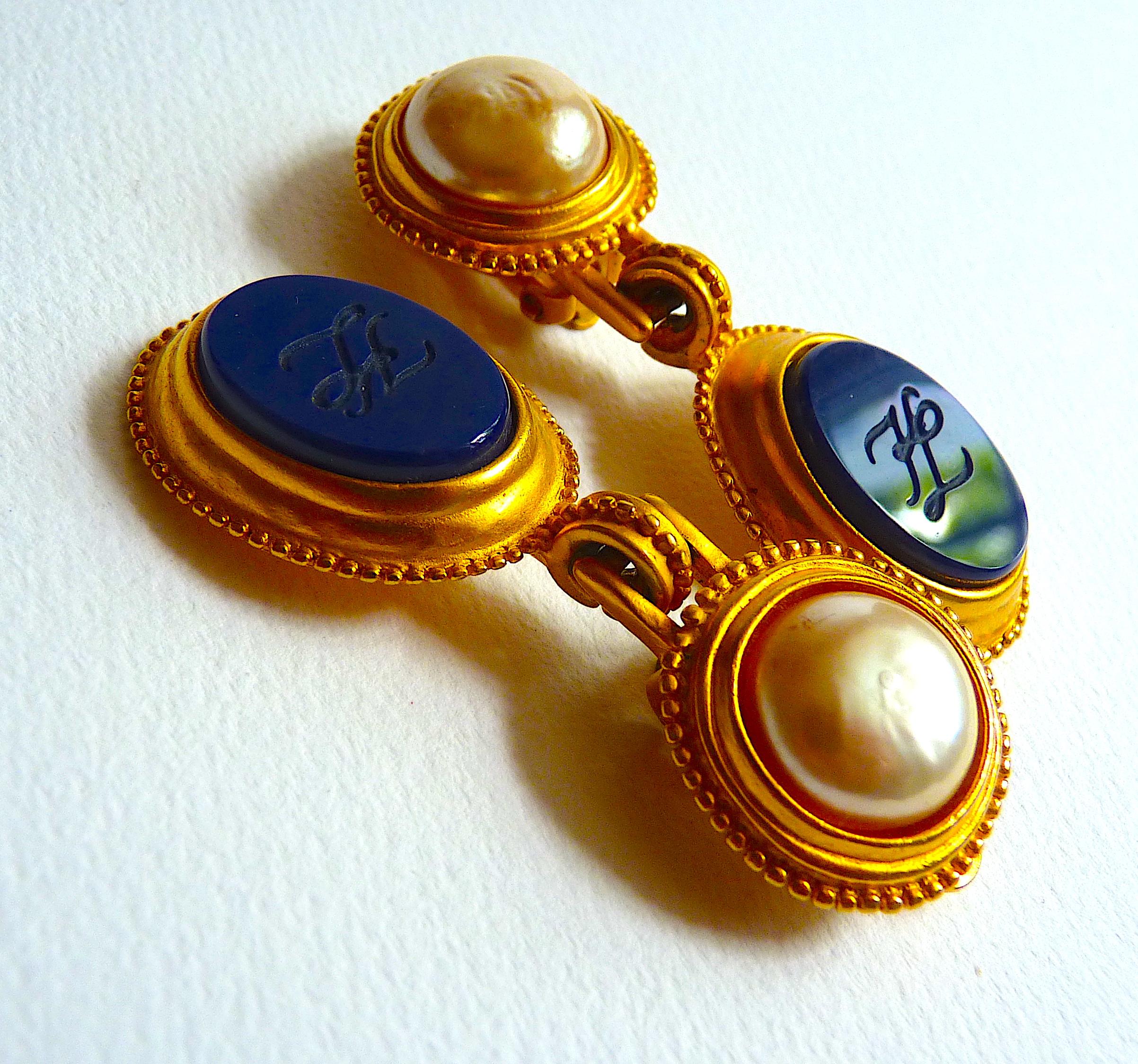 KARL LAGERFELD Drop Earrings, Gold tone Metal, White Faux Pearl and Deep Blue Stone imitating Onyx, engraved with a KL Monogram, Vintage from the 80s
Stamped at Back with the Monogram KL and the famous fan which was a Signature for many 1980s and