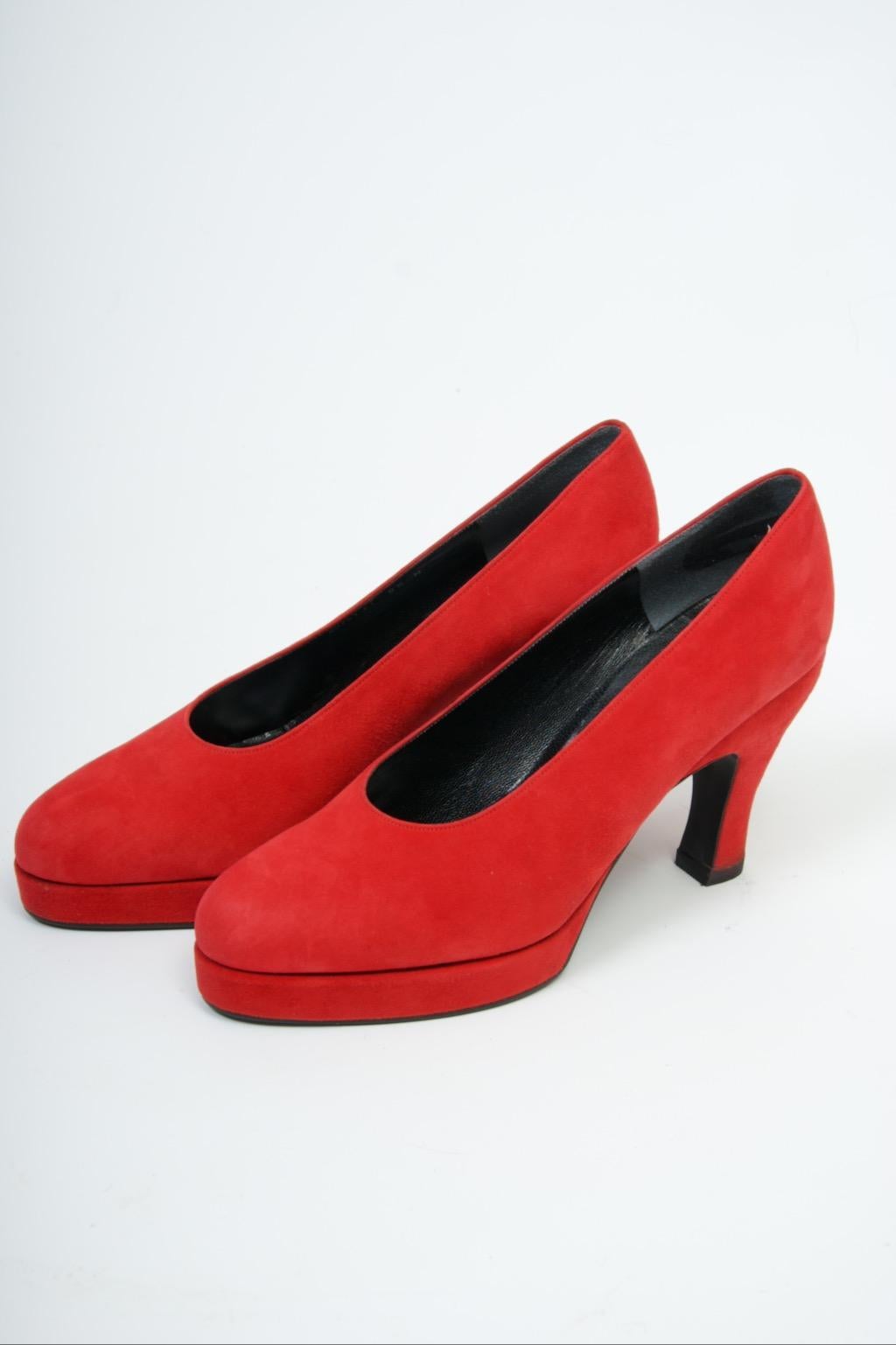 Karl Lagerfeld classic platform pumps in vivid red suede with oval vamp and rounded toe. The shaped heel has an indentation near the top. Black lining with Karl Lagerfeld script labels; fan logo on bottoms. Appear to be unworn, probably from the