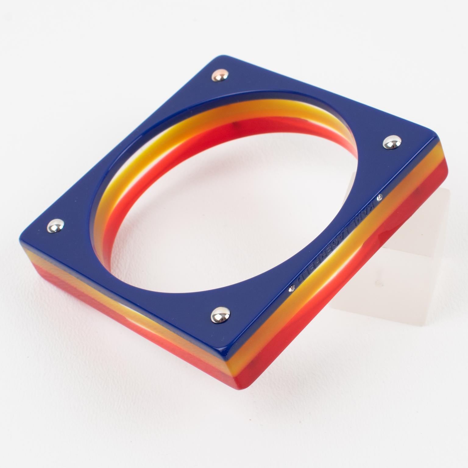 Karl Lagerfeld Paris designed this elegant laminated resin bracelet bangle. The bangle is square-shaped with a multi-layers lamination process in red, yellow, and blue colors with transparency. The engraved 