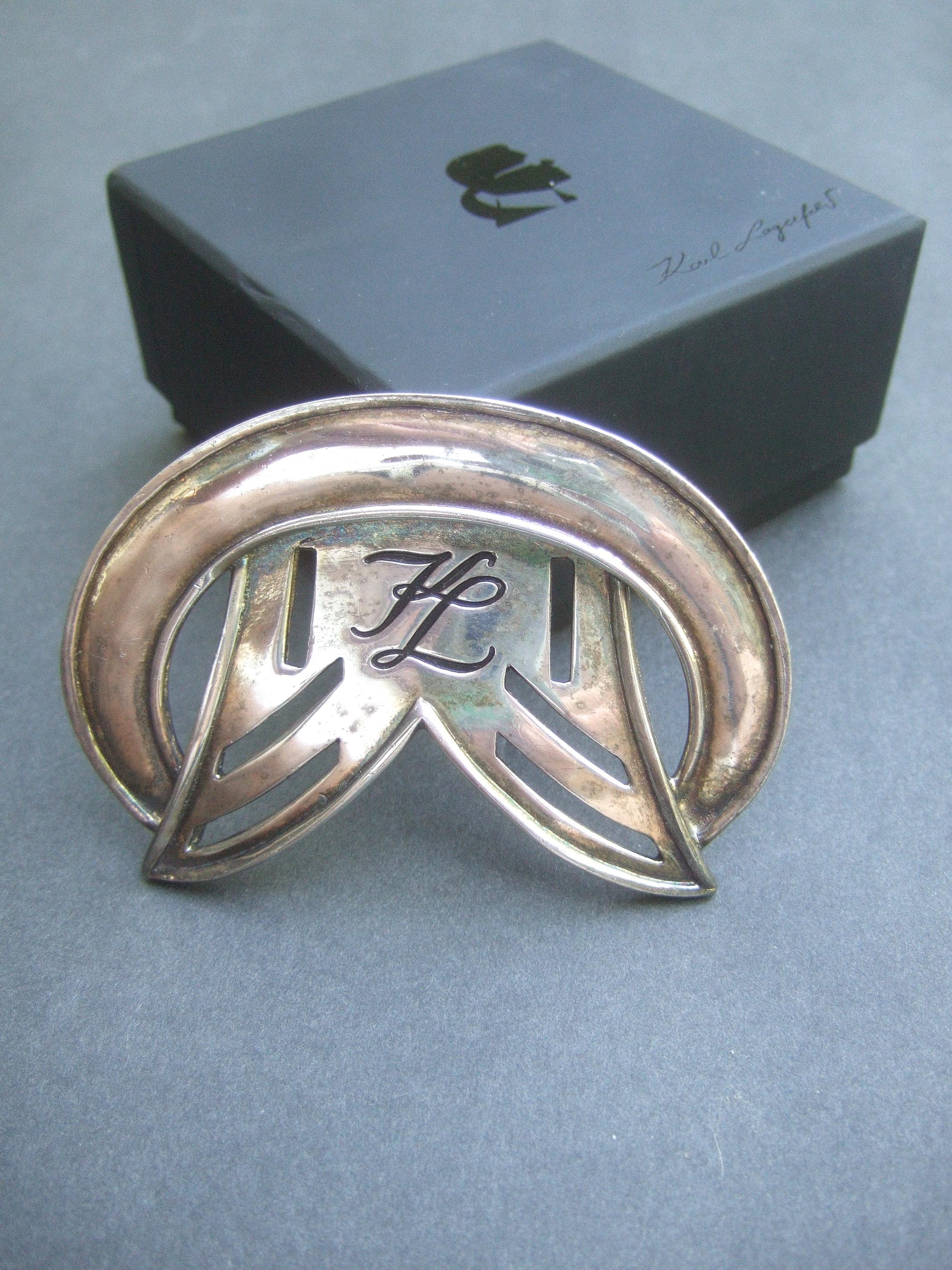Karl Lagerfeld Sleek large silver metal designer brooch in K.L. presentation box c 1980s
The large scale silver metal brooch is designed with Karl Lagerfeld's
iconic script initials with black enamel 

The curved upper section and sides are