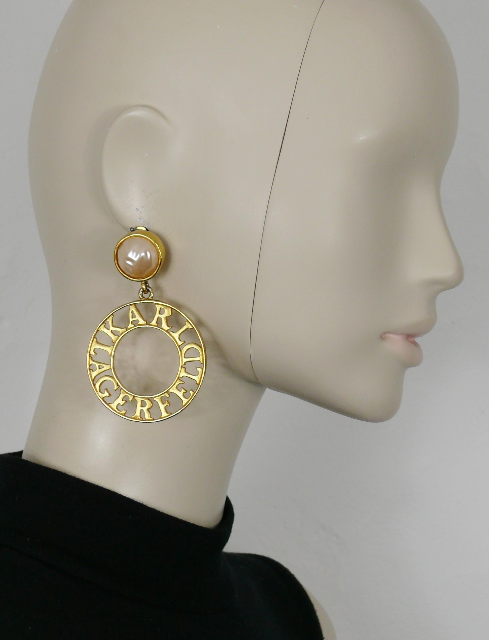 KARL LAGERFELD vintage gold tone hoop earrings (clip-on) featuring an irregular shape faux resin pearl top and a cut out KARL LAGERFELD spelling pendant.

Embossed KL.

Indicative measurements : max. height approx. 7.8 cm (3.07 inches) / max. width