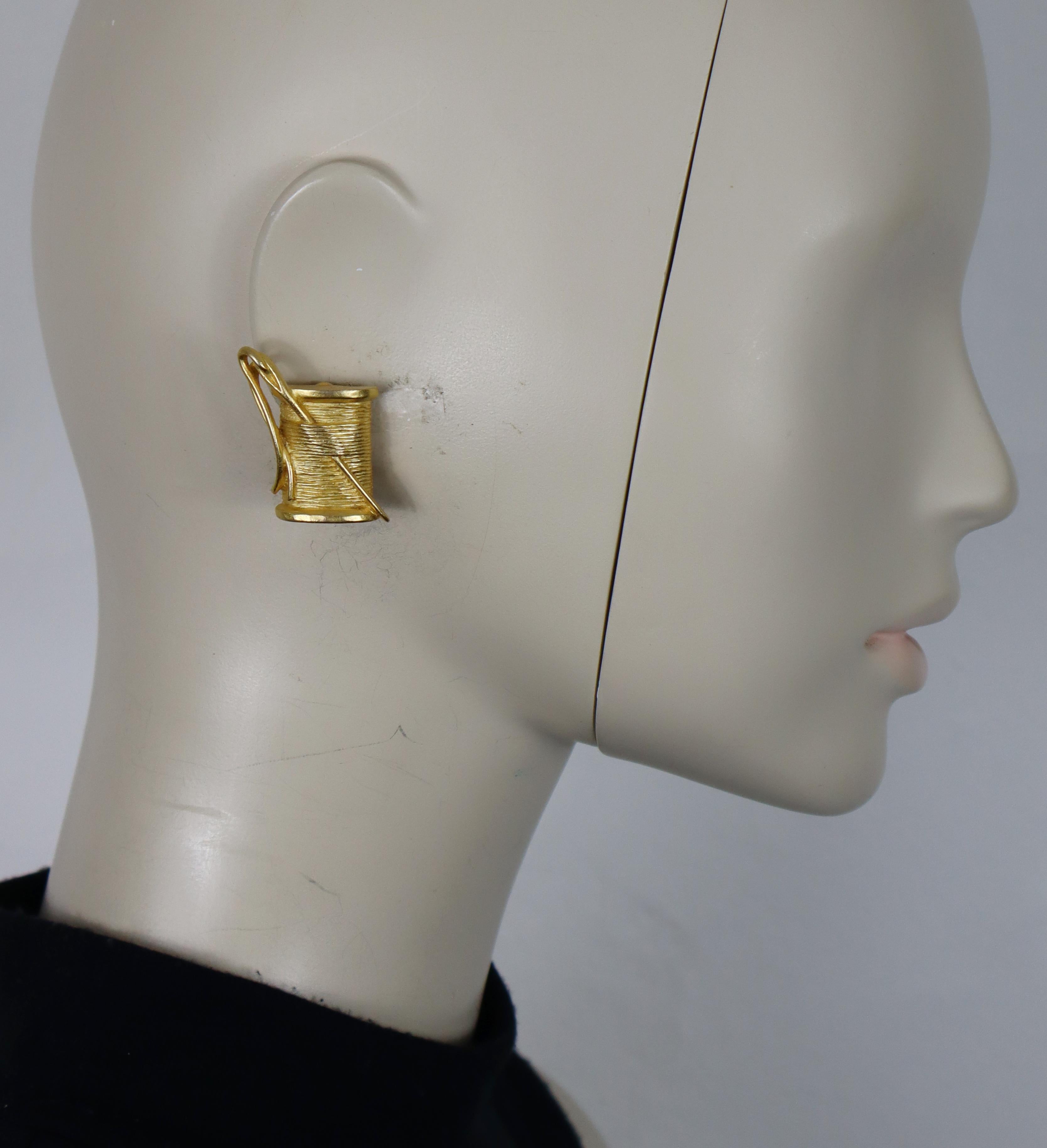 KARL LAGERFELD vintage gold tone clip-on earrings featuring a thread spool and a needle.

Embossed KL.

Indicative measurements : max. height approx. 3 cm (1.18 inches) / max. width approx. 2.6 cm (1.02 inches).

Weight per earring : approx. 12