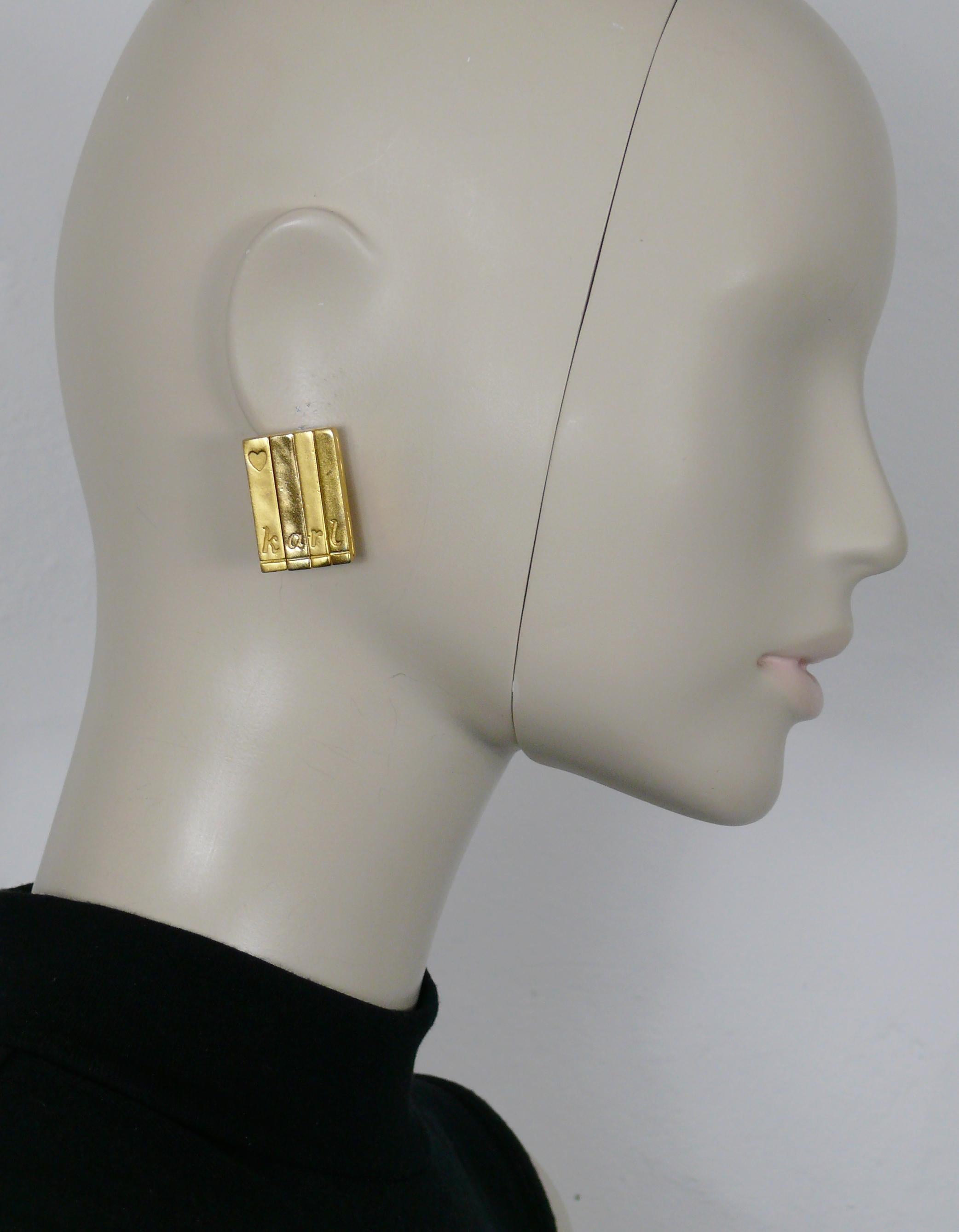 KARL LAGERFELD vintage gold toned rectangular clip-on earrings featuring book spines embossed with a heart and K A R L.

Embossed KL on the reverse side.

Indicative measurements : height approx. 3 cm (1.18 inches) / width approx. 2 cm (0.79