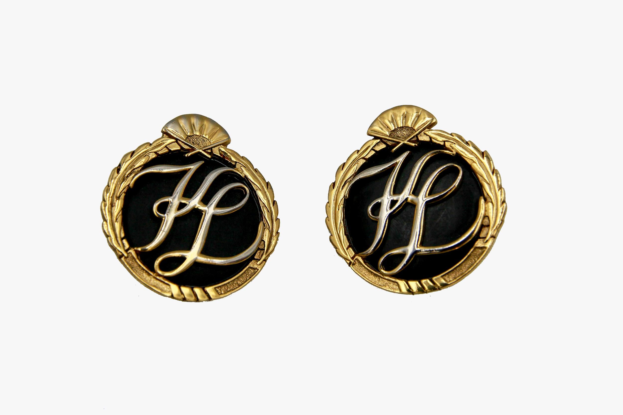 Karl Lagerfeld vintage oversized clip-on earrings featuring KL monogram on black enamel framed in gold tone wreath with a fan on the top.

Signed.

Period: 1990s

Condition: Very Good. Minor scratches throughout metal.

Diameter: 4