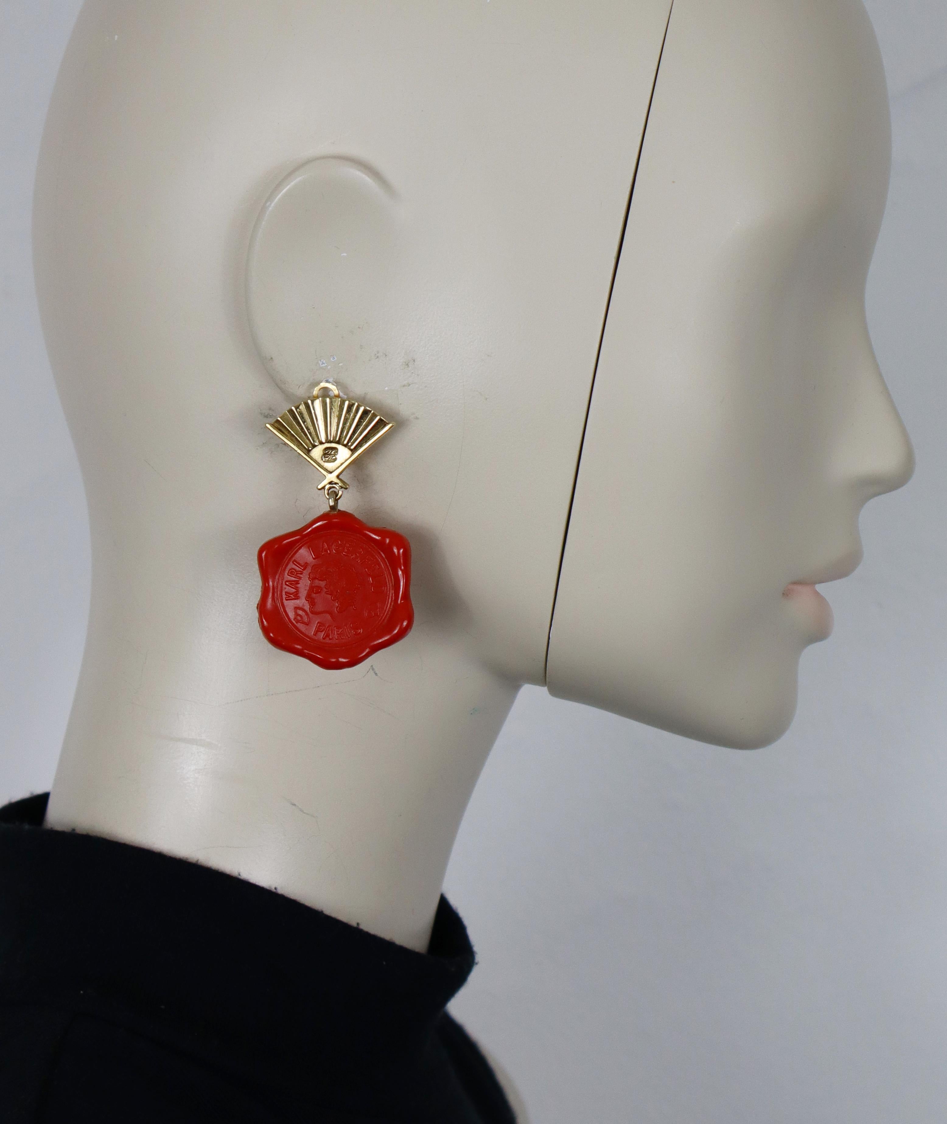 KARL LAGERFELD vintage iconic gold tone dangling earrings (clip-on) featuring a fan top and a red resin wax-like seal embossed with a profile and KARL LAGERFELD PARIS.

Embossed KL on the fan front sides.

Indicative measurements : max. height