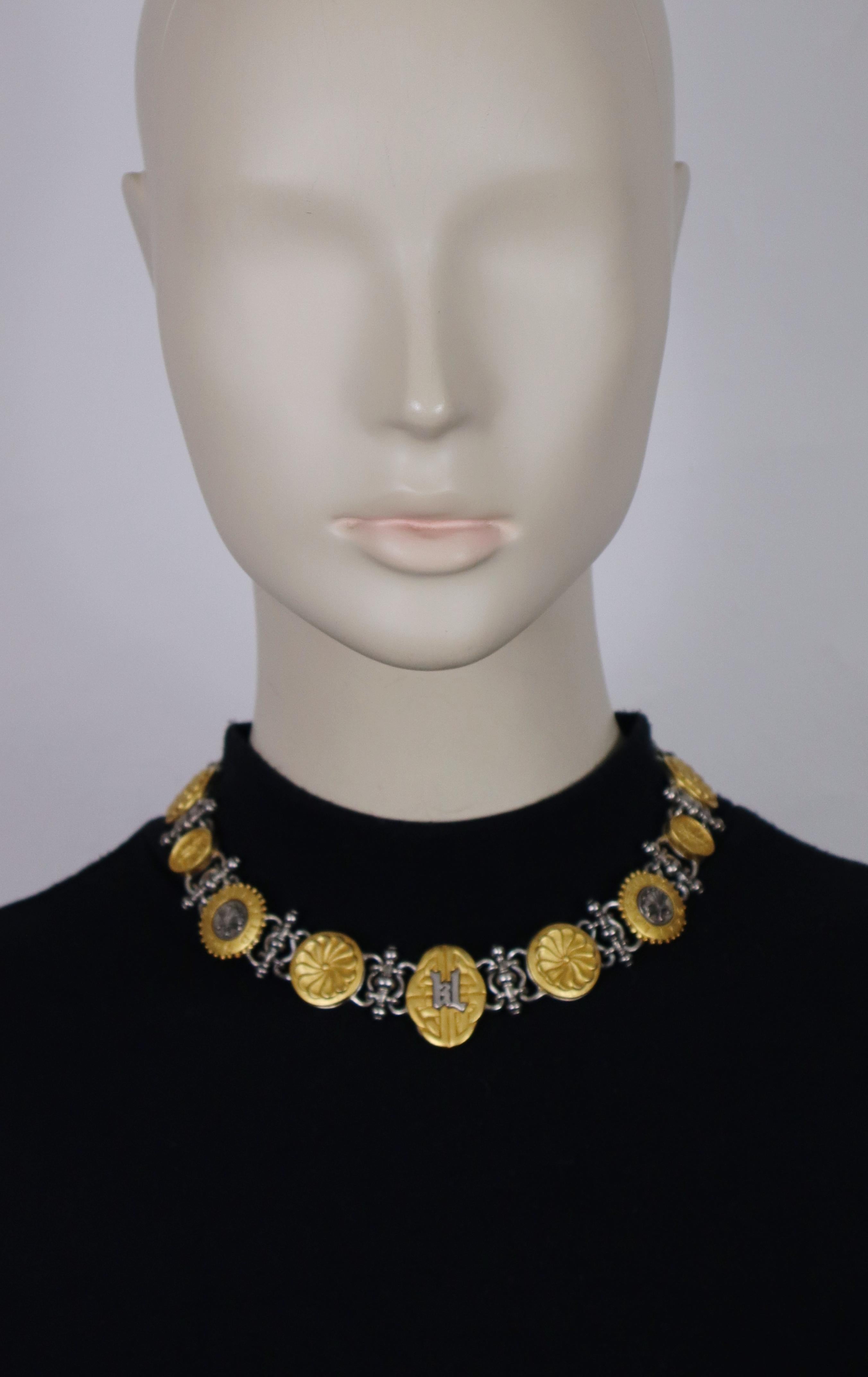 Collana con emblema a medaglione KARL LAGERFELD vintage in oro opaco e argento anticato.

Chiusura a gancio regolabile.

KL in rilievo sul retro e sul cartellino.
Datato 1996.

Misure indicative: lunghezza regolabile da circa 40 cm (15,75 pollici) a