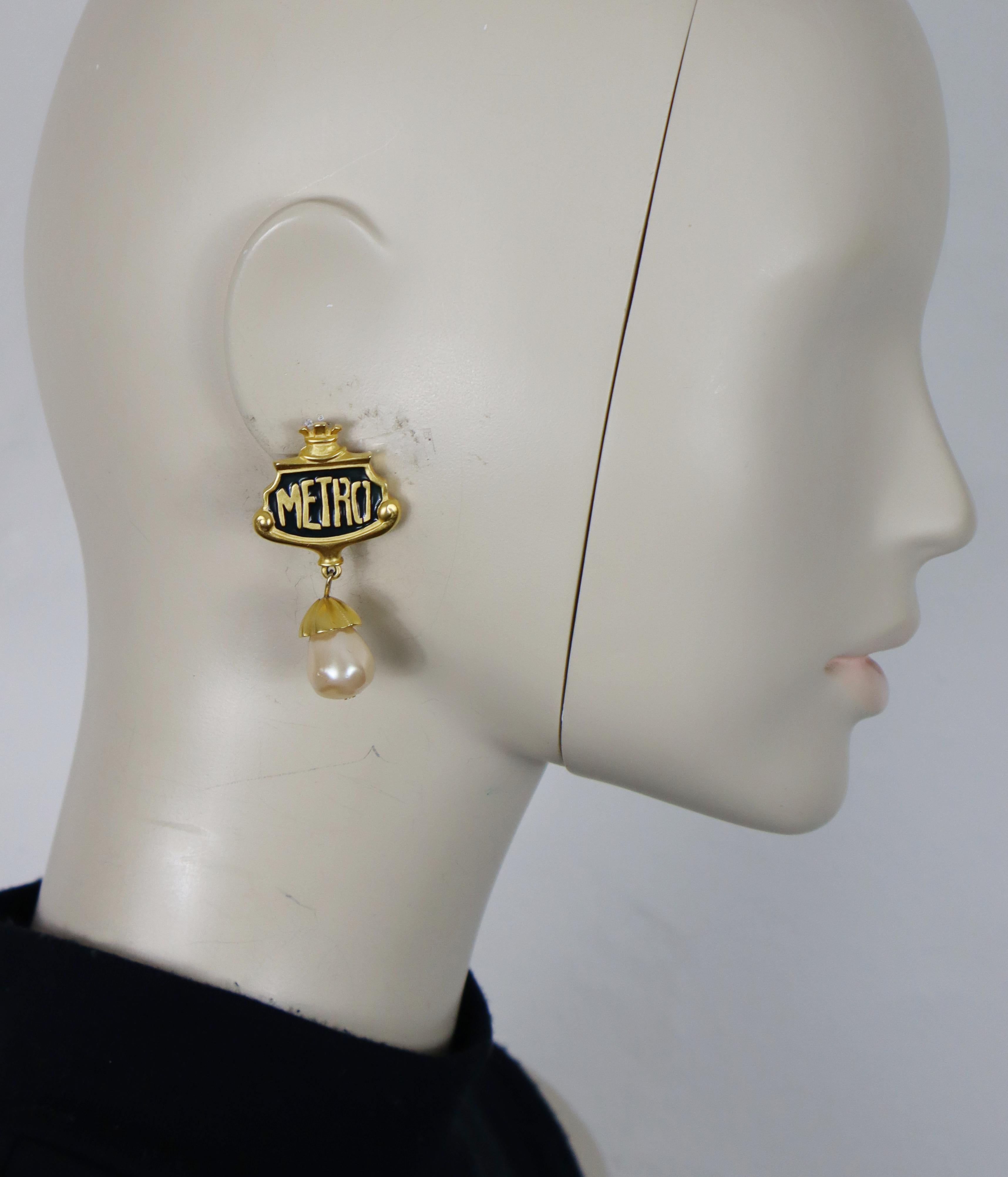 KARL LAGERFELD vintage gold tone dangle earrings (clip-on) featuring a Parisian metro station sign embellished with black enamel and an acrylic faux pearl drop

Embossed KL.

Indicative measurements : max. height approx. 5.2 cm (2.05 inches) / max.