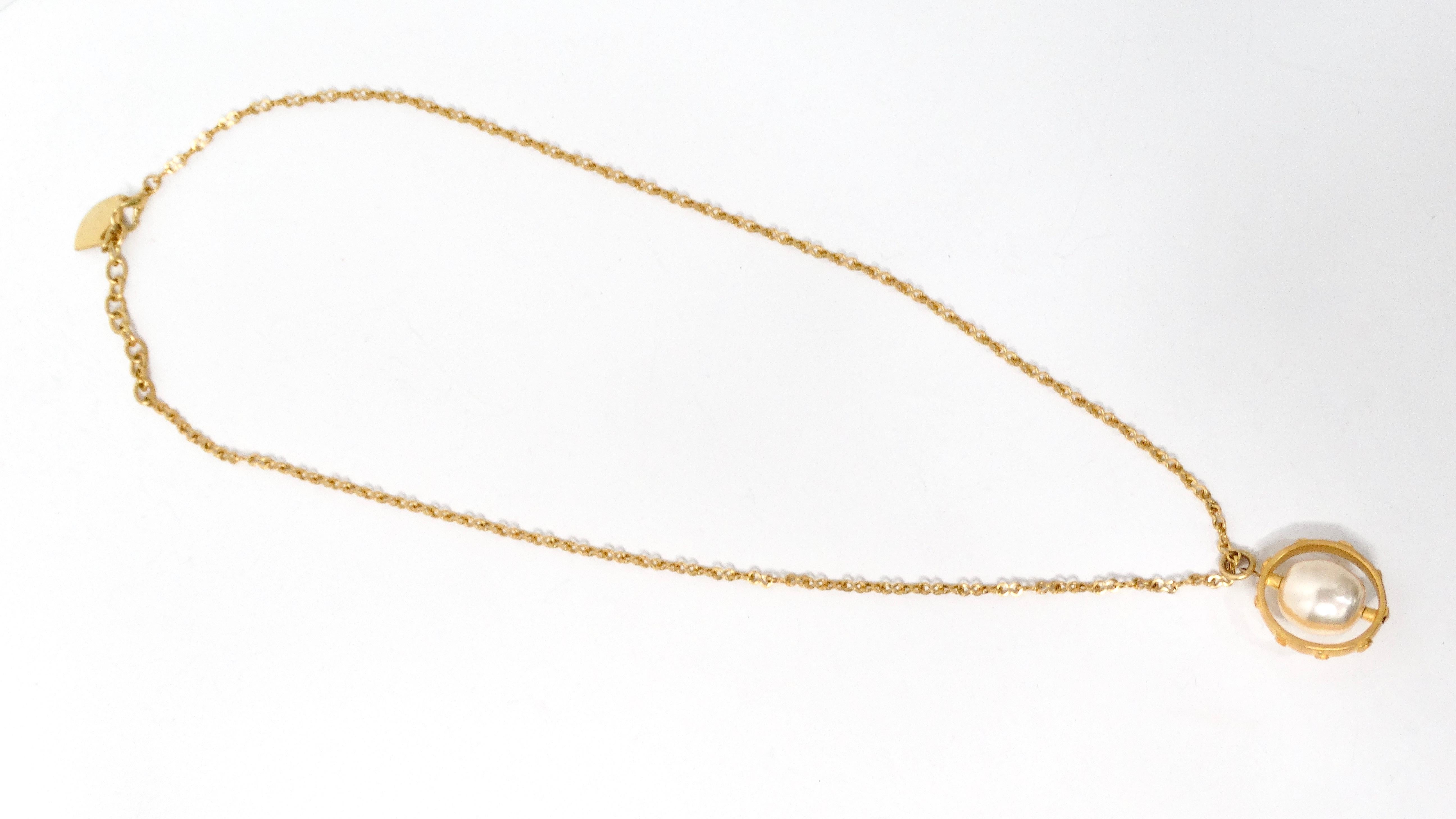 La collana con ciondolo di perle Karl Lagerfeld Vintage Rotating Costume è un pezzo straordinario che combina magistralmente eleganza e innovazione. Questa lunga collana placcata in oro presenta una perla finta di grandi dimensioni che ruota con