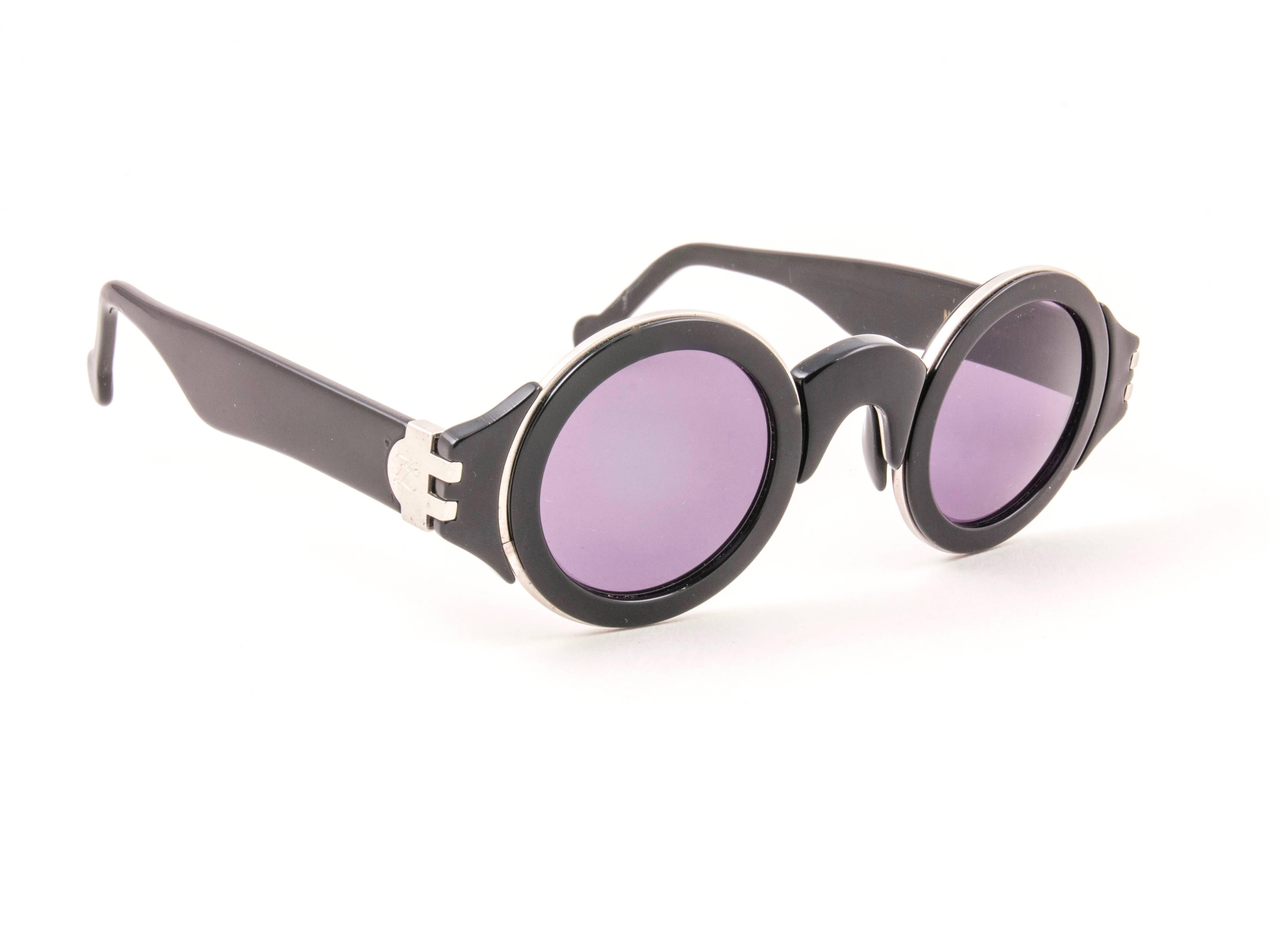 Striking pair of vintage Karl Lagerfeld 1184 Round black & silver inserts sunglasses sporting a spotless pair of grey lenses.   

New, never used or displayed, this pair of vintage Karl Lagerfeld is a rare sought after piece not to miss out!