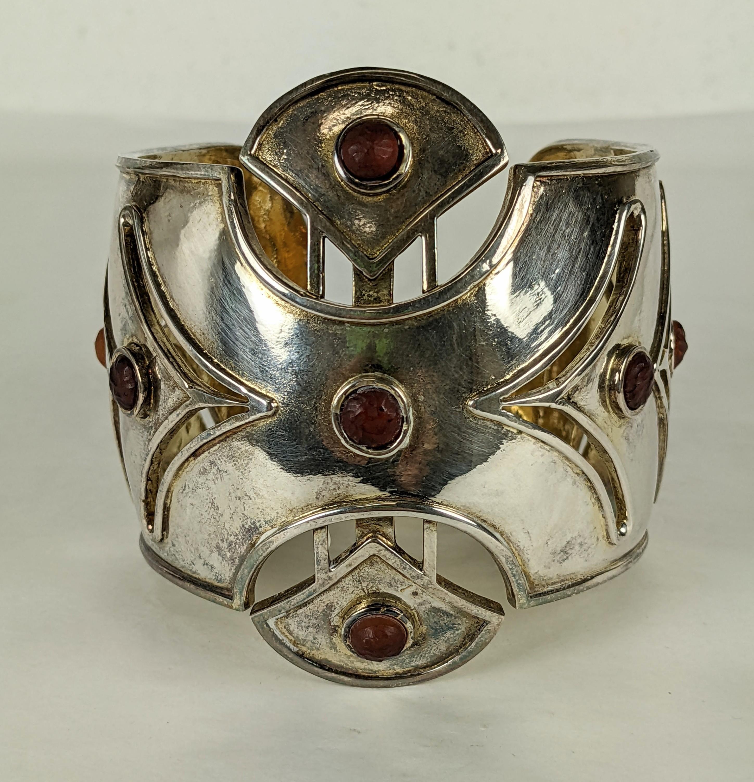 Massive Karl Lagerfeld Weiner Werkstatte cuff in silver toned metal with foiled cabochons in hammered carnelian pate de verre. Huge in scale with arrow cut outs to create Secessionist patterns. 1980's France. Signed 